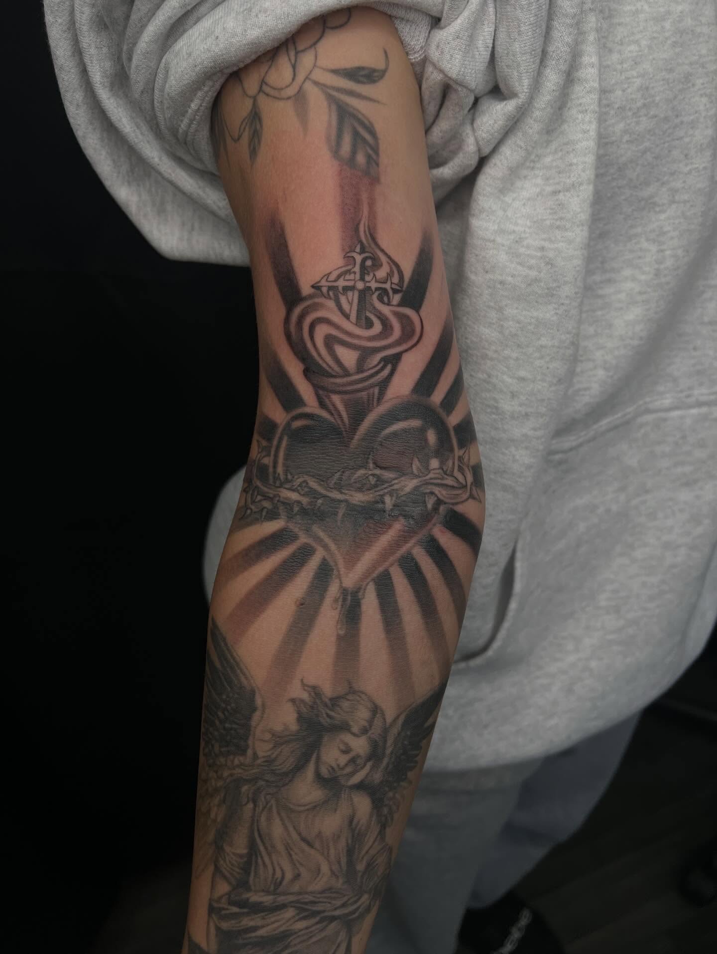 Heart with crown of thorns black and grey tattoo on the forearm by San Diego Fineline Black & Grey Tattoo Artist