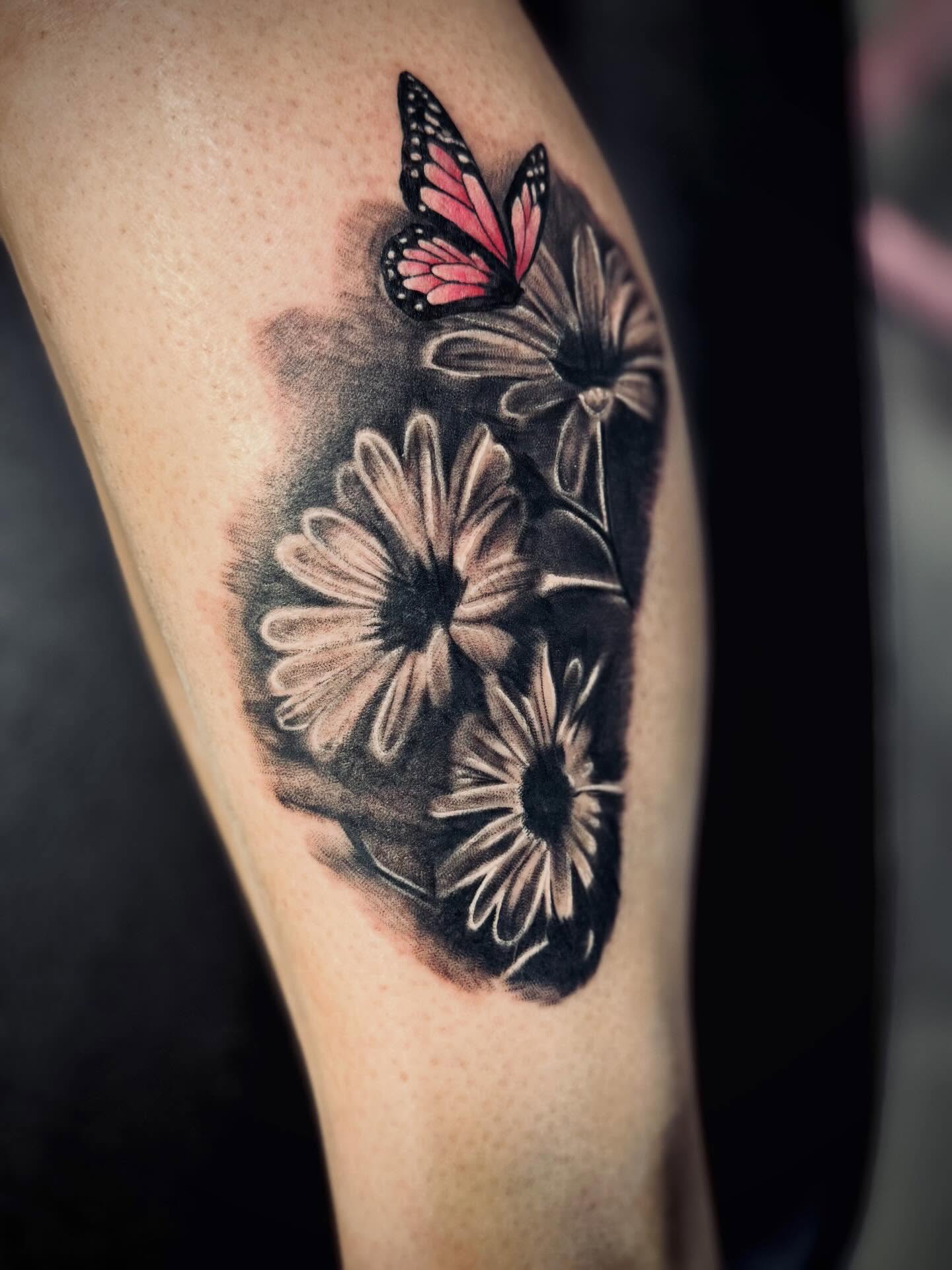 Flowers and butterfly black and grey tattoo on the thigh by Katelyn Arnold