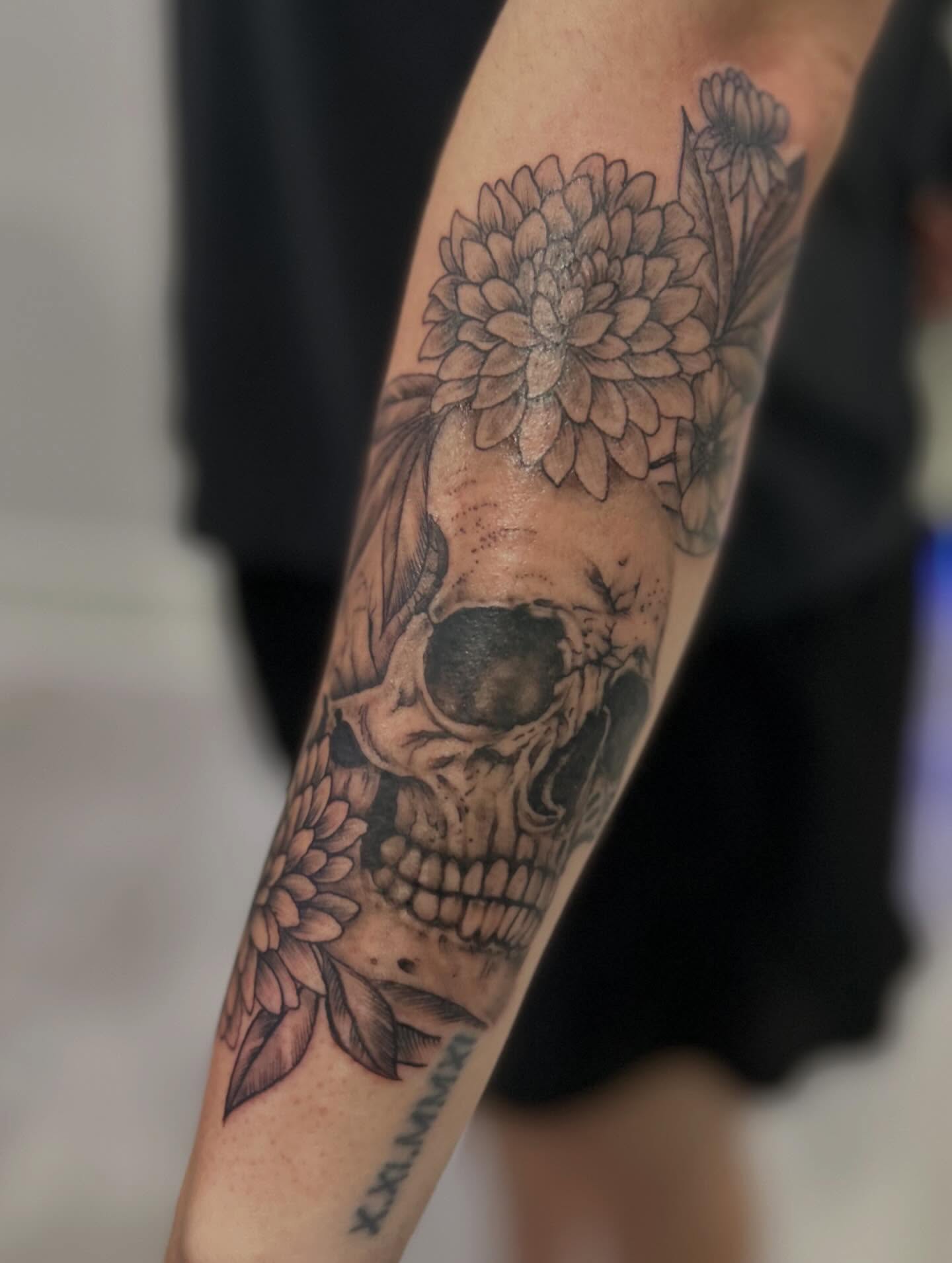 Skull and flowers realism tattoo on the forearm by Jbtattoo Artistry