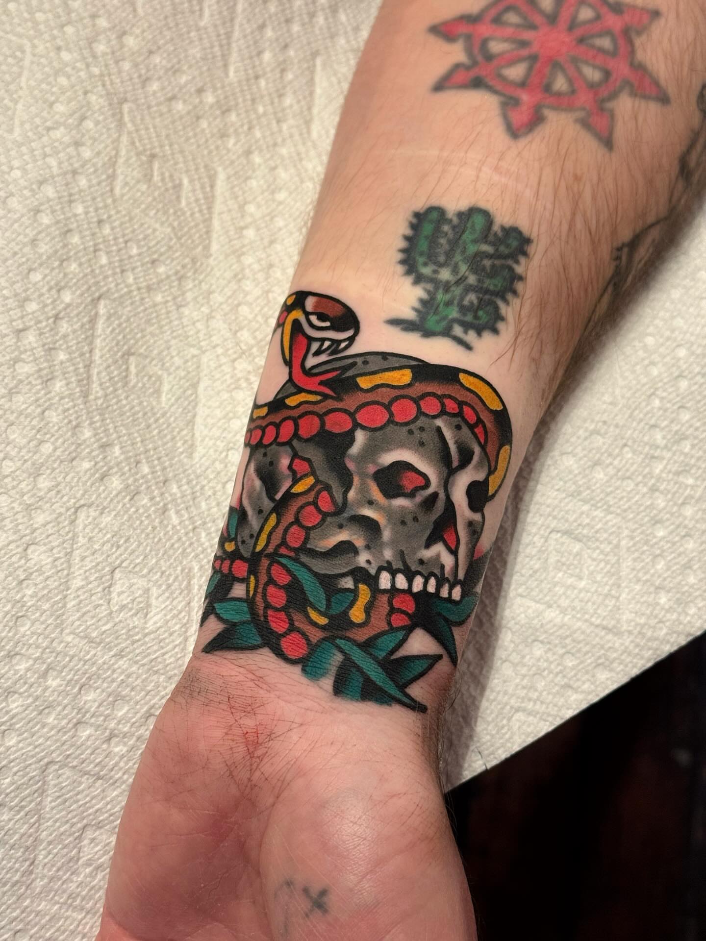 Skull with snake American traditional tattoo on the forearm by Bryce Shearer