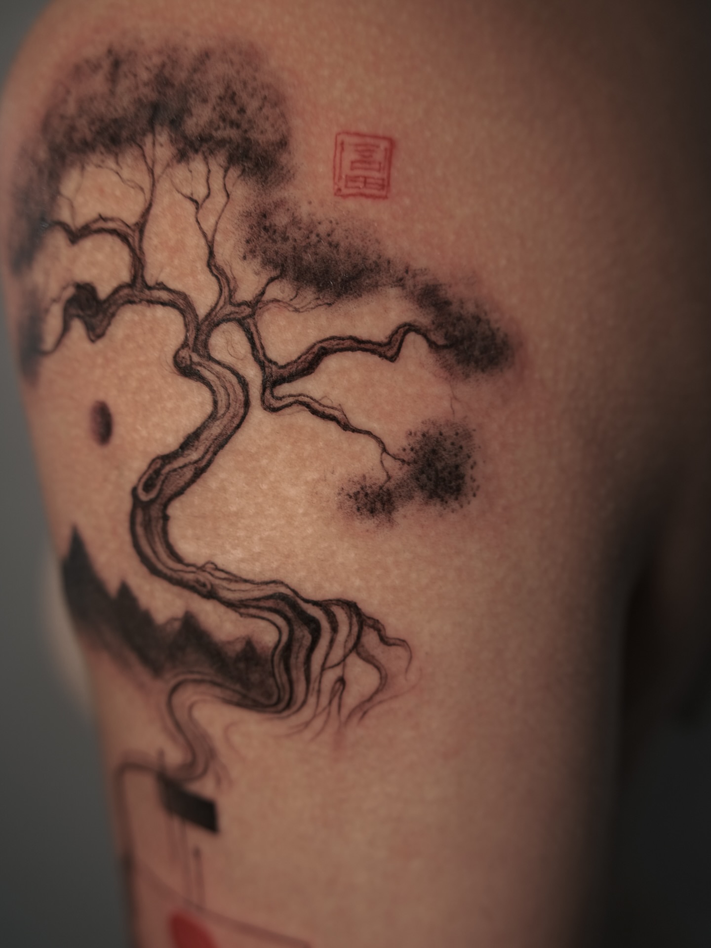 Bonsai tree black and grey tattoo on the upper arm by Lily K.