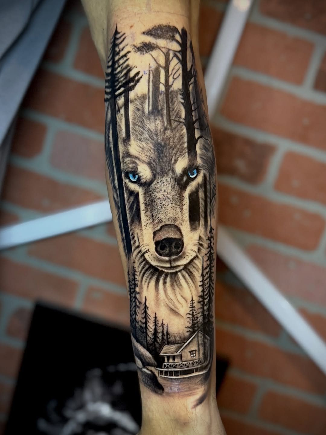 Wolf in forest with cabin realism tattoo on the forearm by Andres Calvo🇺🇸🇨🇴