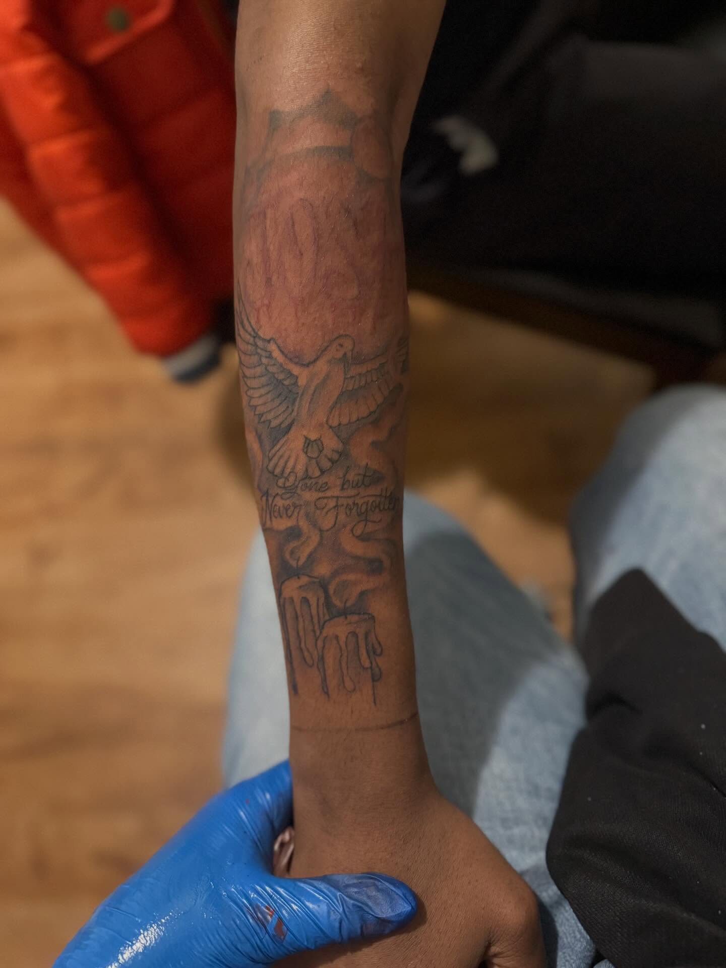 Bird and flame black and grey tattoo on the forearm by Aja Marie
