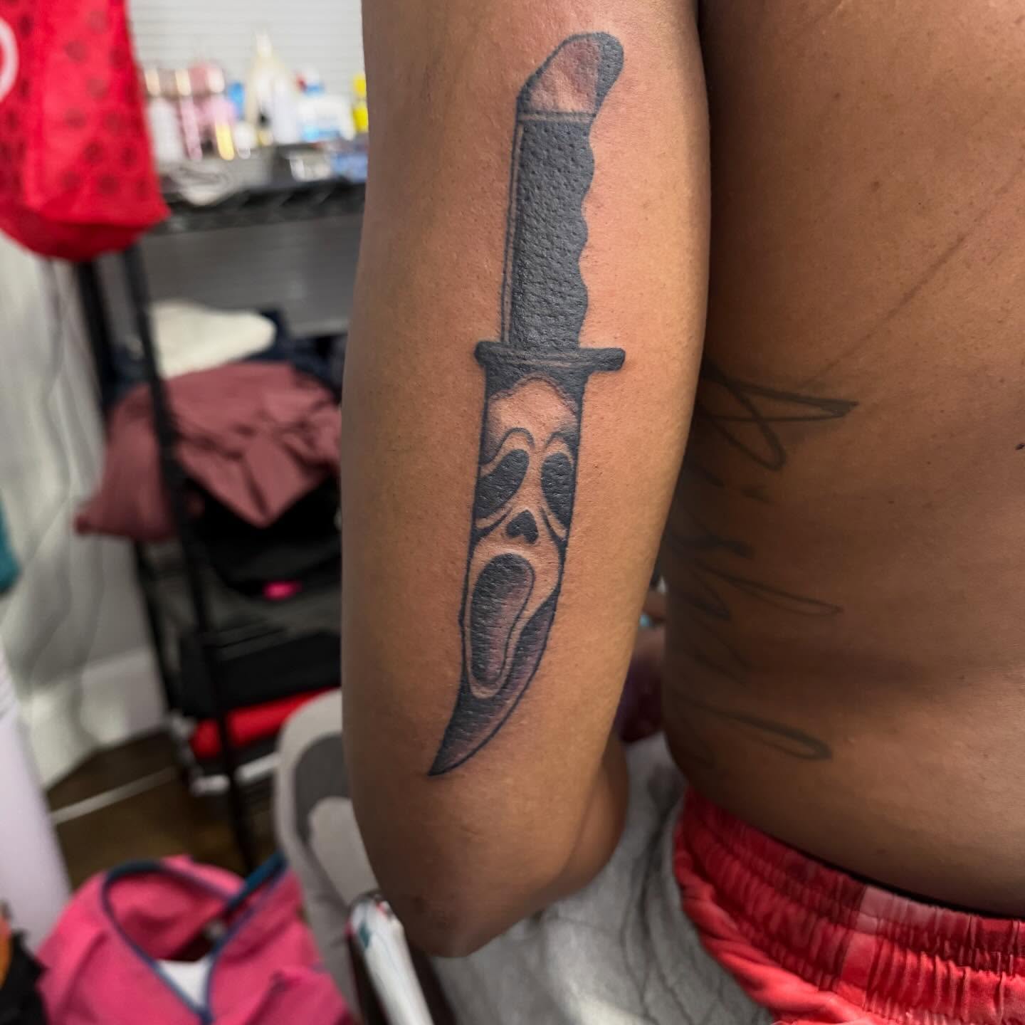 Knife with scream face realism tattoo on the forearm by Aja Marie