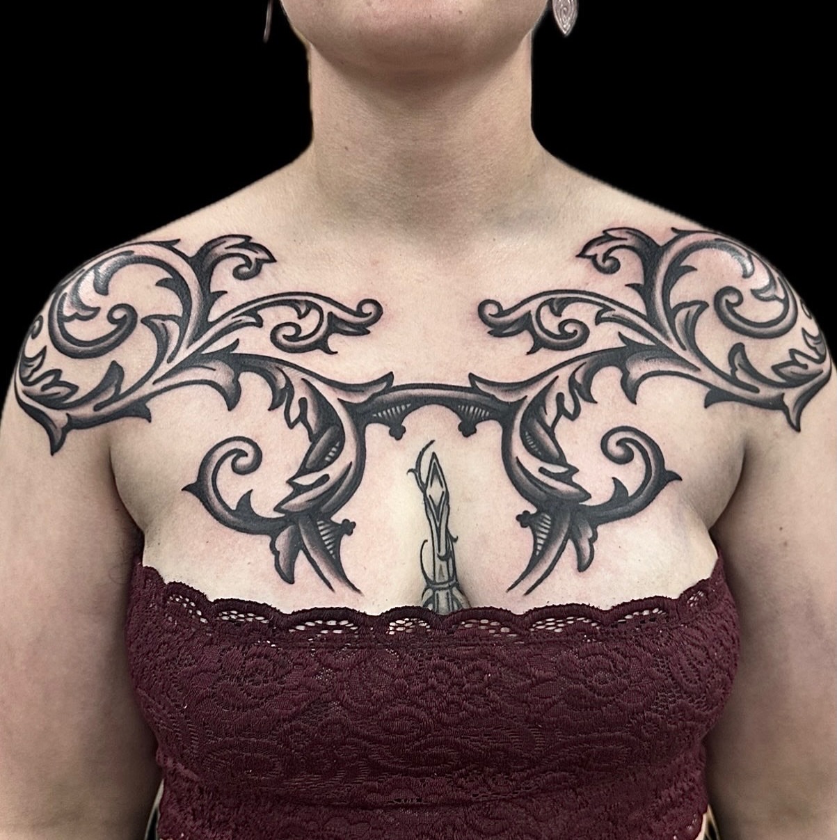 Scrollwork tribal tattoo on the chest by Madeline Brown