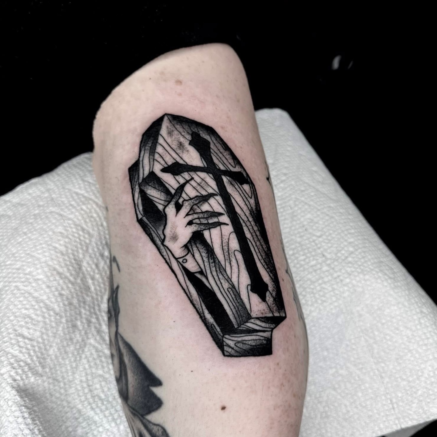 Coffin with cross black and grey tattoo on the forearm by Brett Brown
