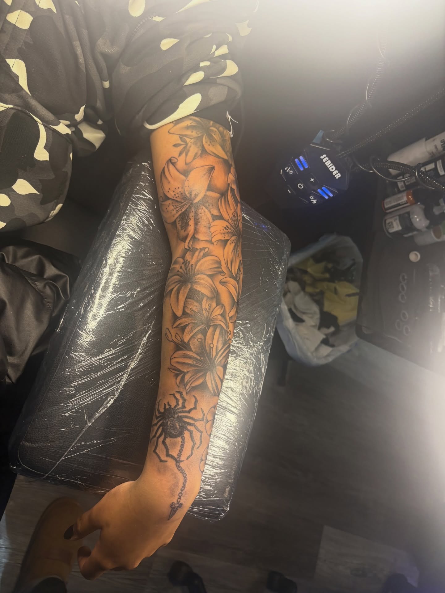 Lilies and spider American traditional tattoo on the forearm by Maleek Inkz
