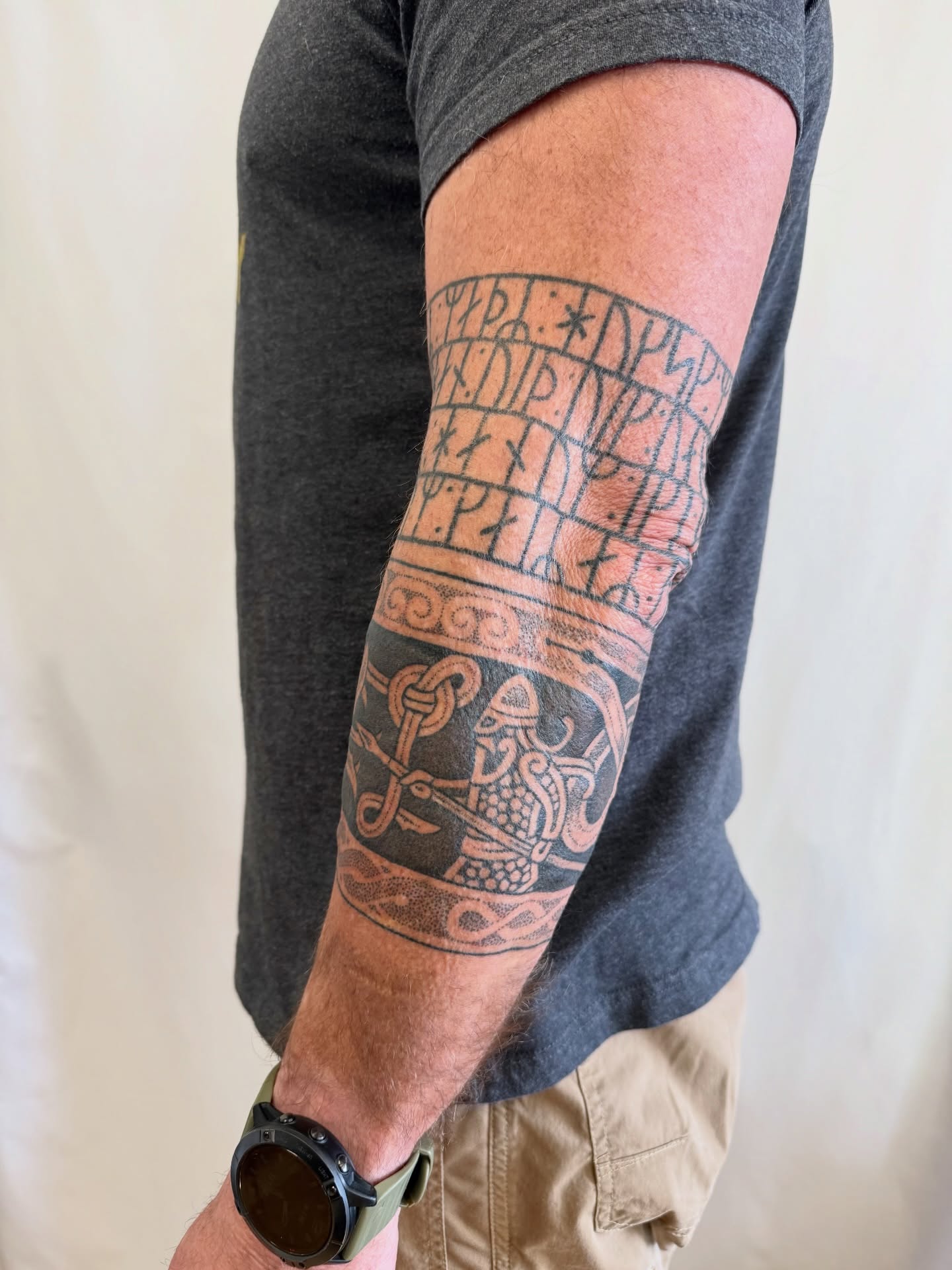 Runes and shield black and grey tattoo on the forearm by Melia Mariko