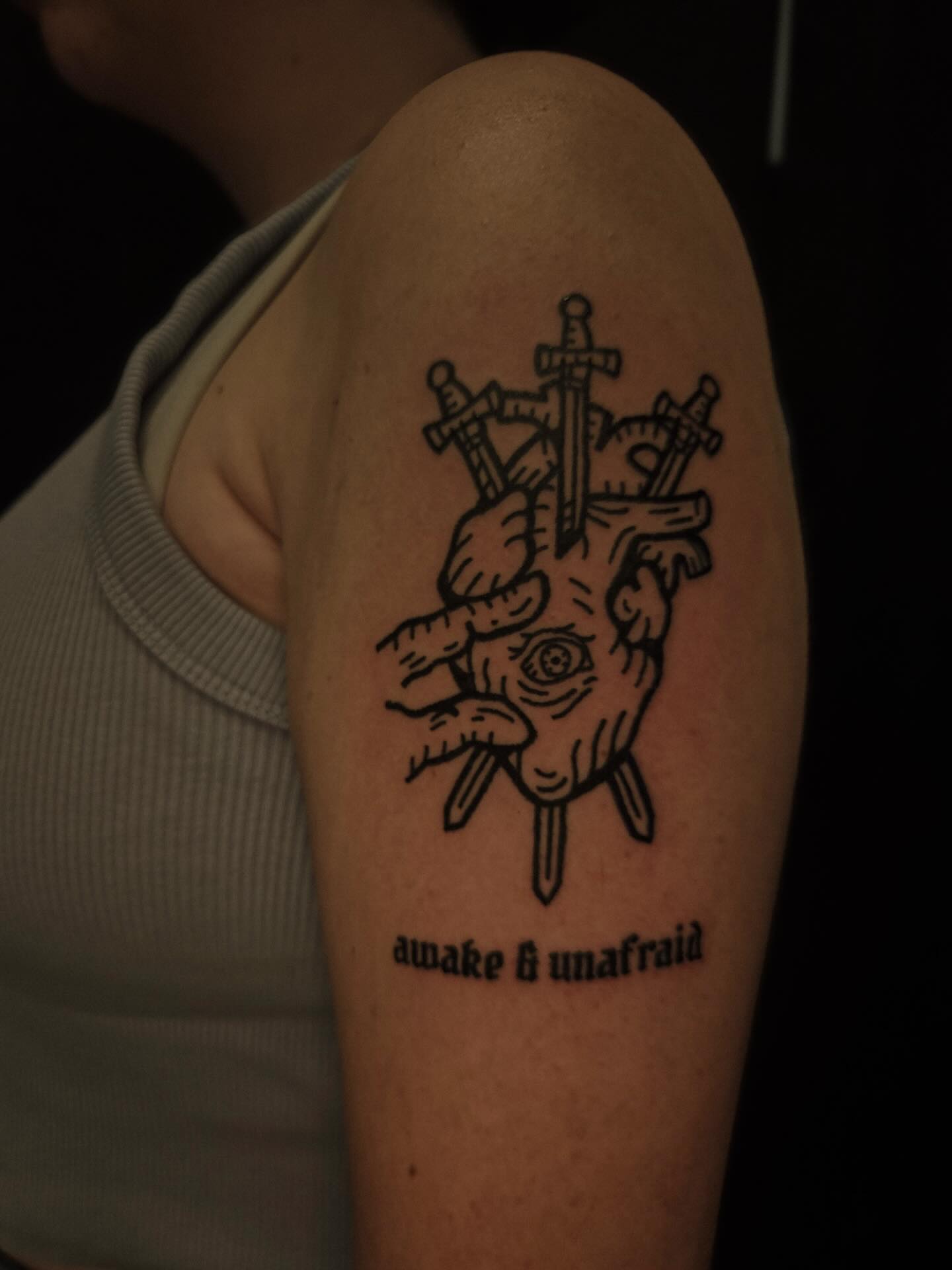 Heart with swords black and grey tattoo on the upper arm by ashley blyght