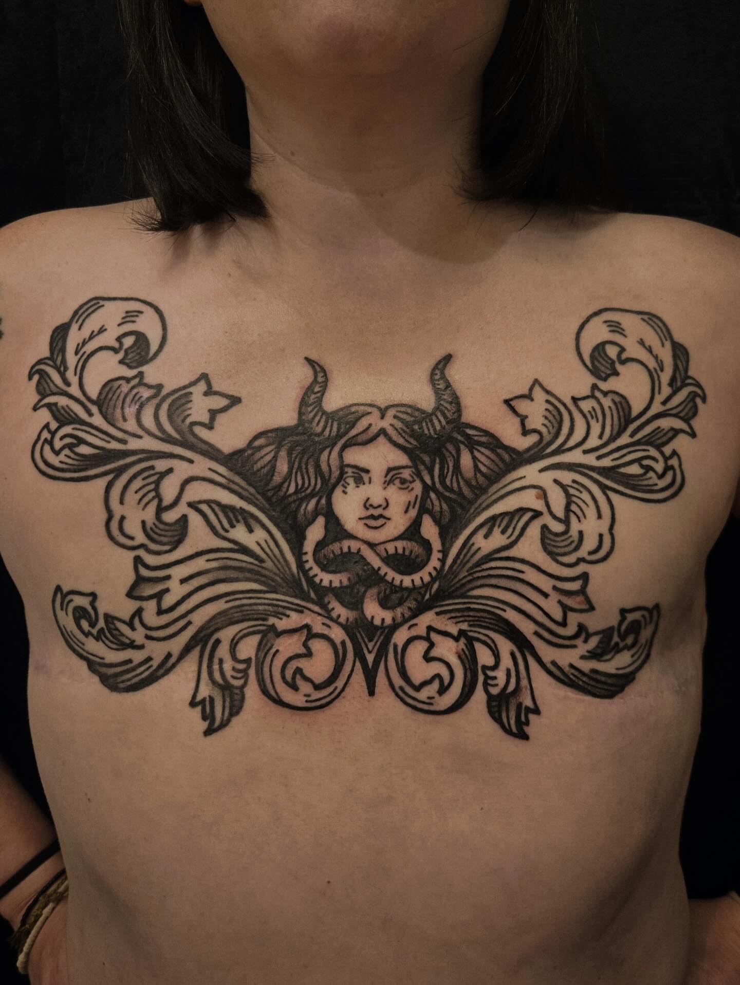 Woman's head with horns American traditional tattoo on the chest by ashley blyght
