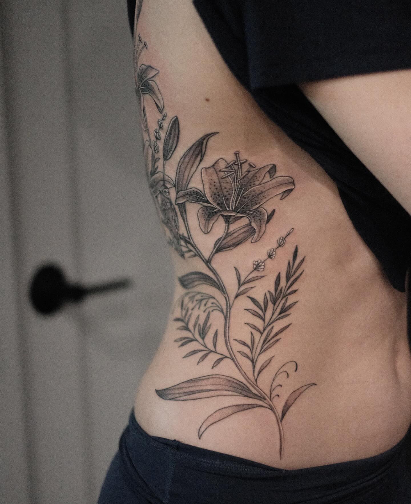 Lily and botanicals black and grey tattoo on the ribs by Isabelle Kellar, San Diego, California