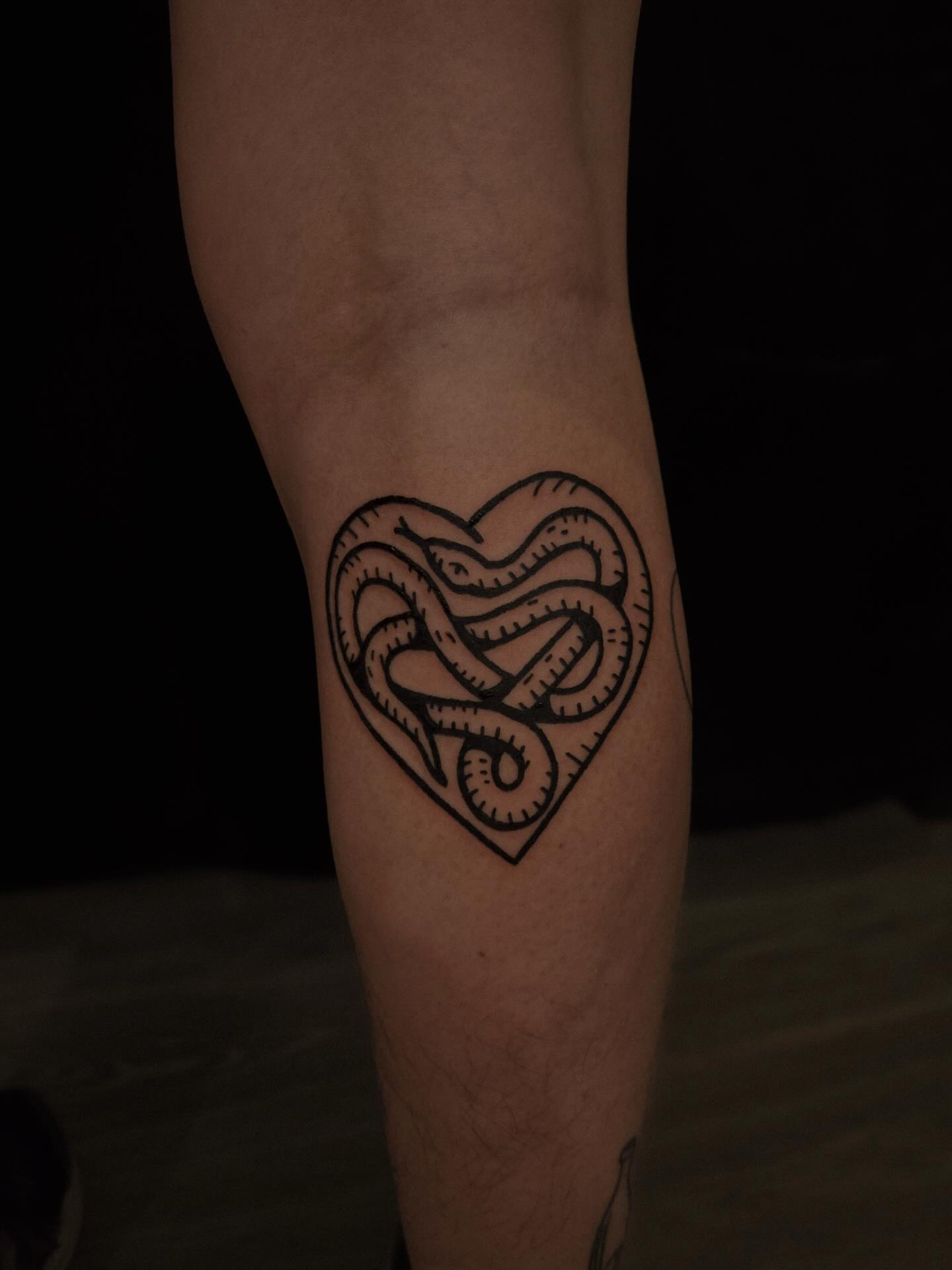 Heart with snakes geometric tattoo on the forearm by ashley blyght