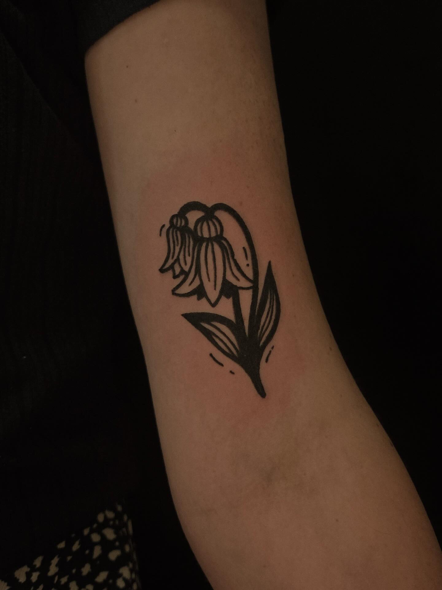 Lily of the valley minimalist tattoo on the forearm by ashley blyght