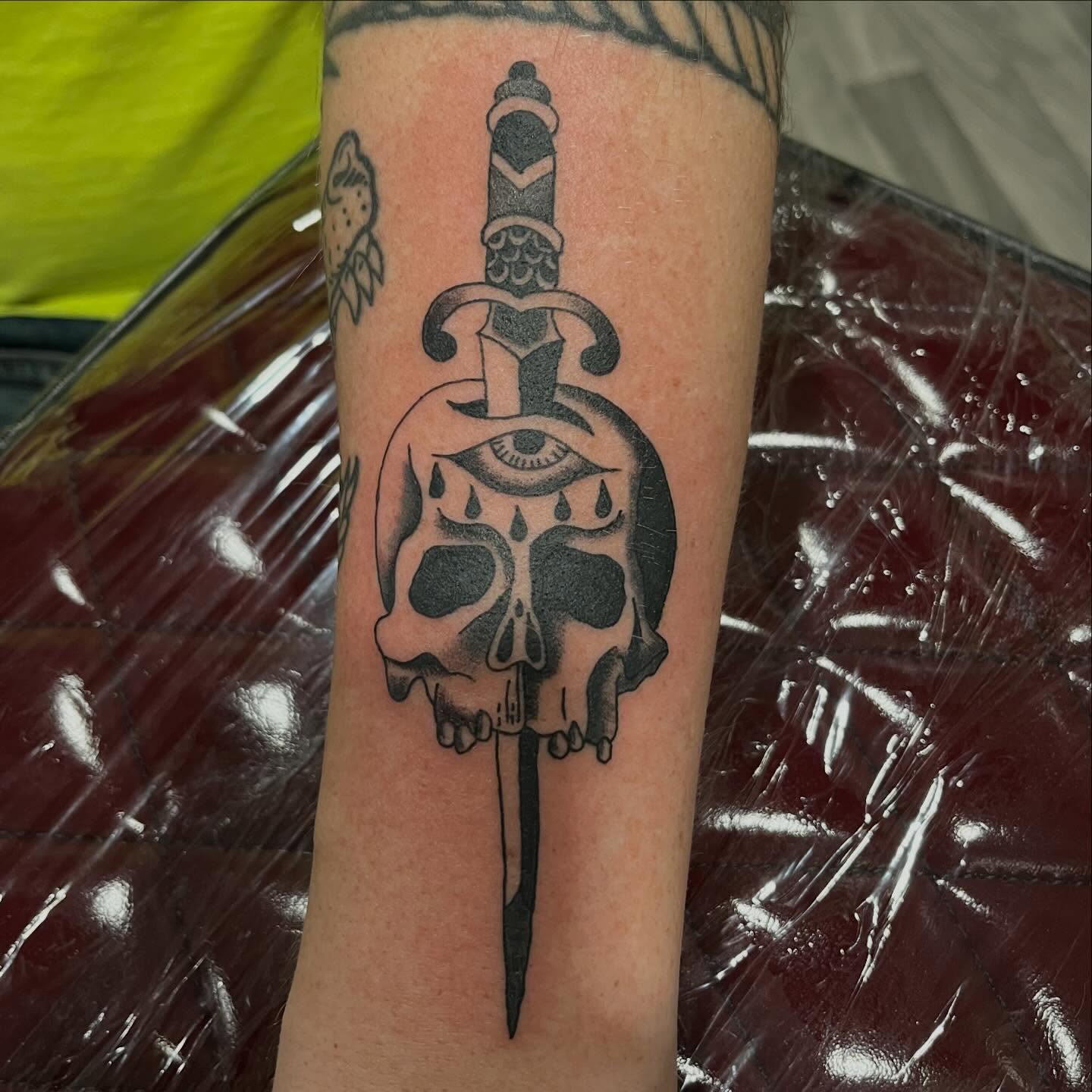 Skull with dagger black and grey tattoo on the forearm by P R O P H e T T R A V I S