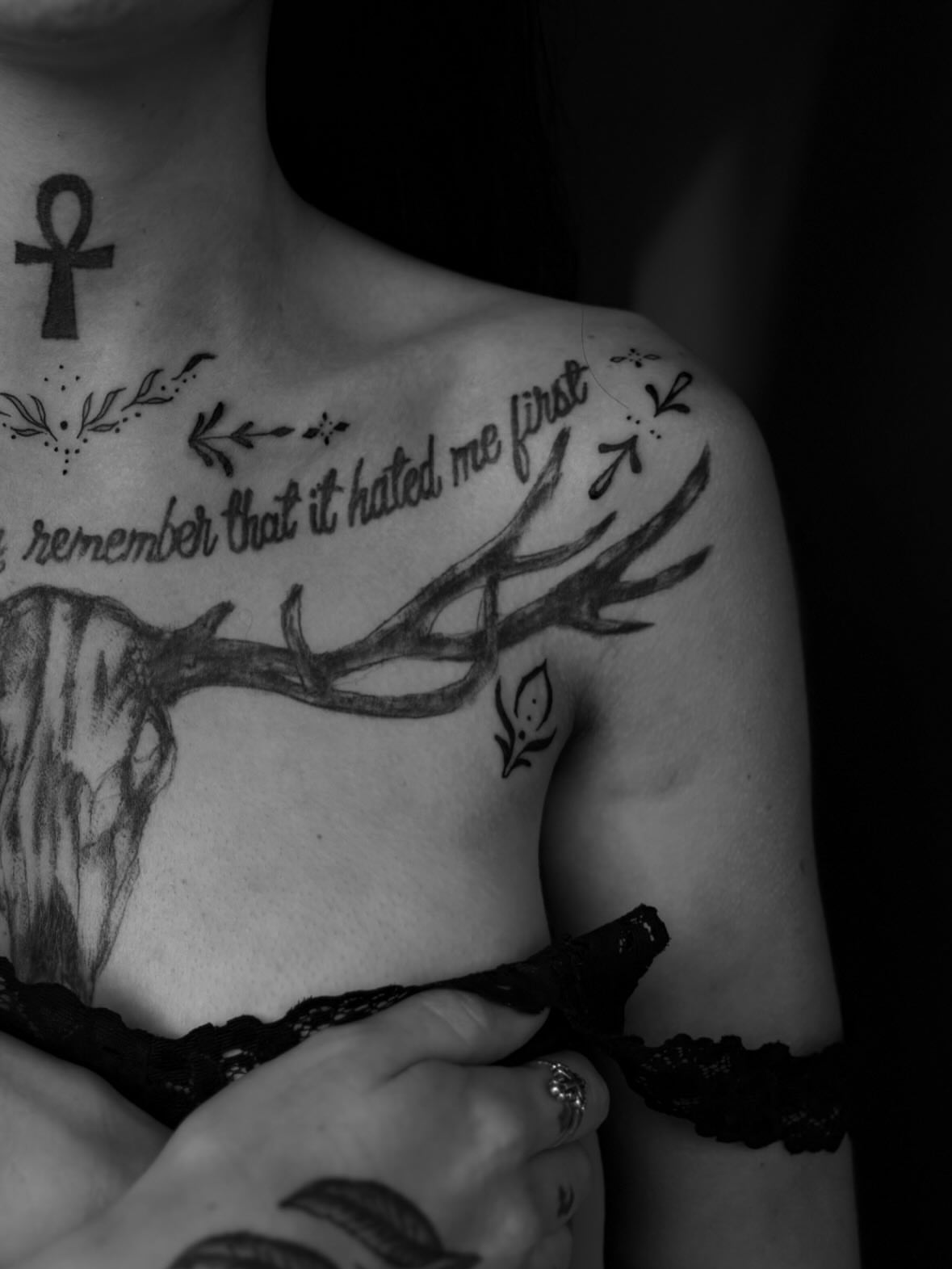 Antlers and script black and grey tattoo on the chest by Lauren Deets
