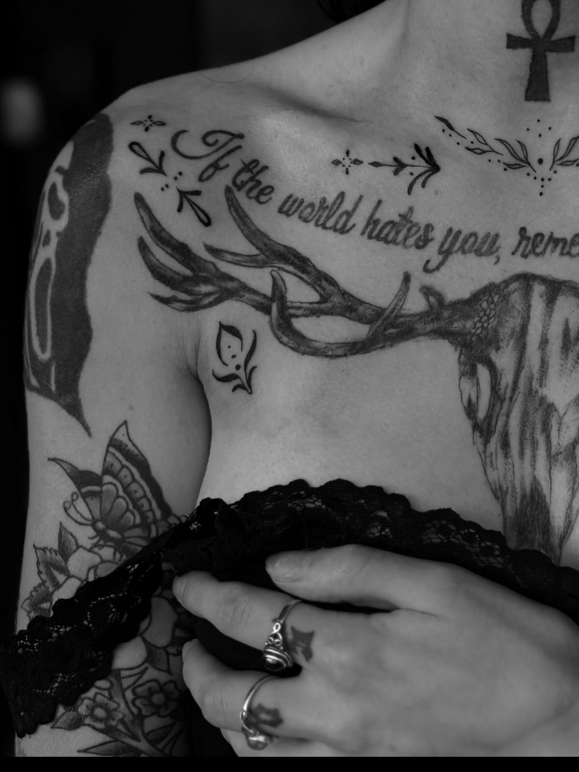 Antlers and script black and grey tattoo on the chest by Lauren Deets