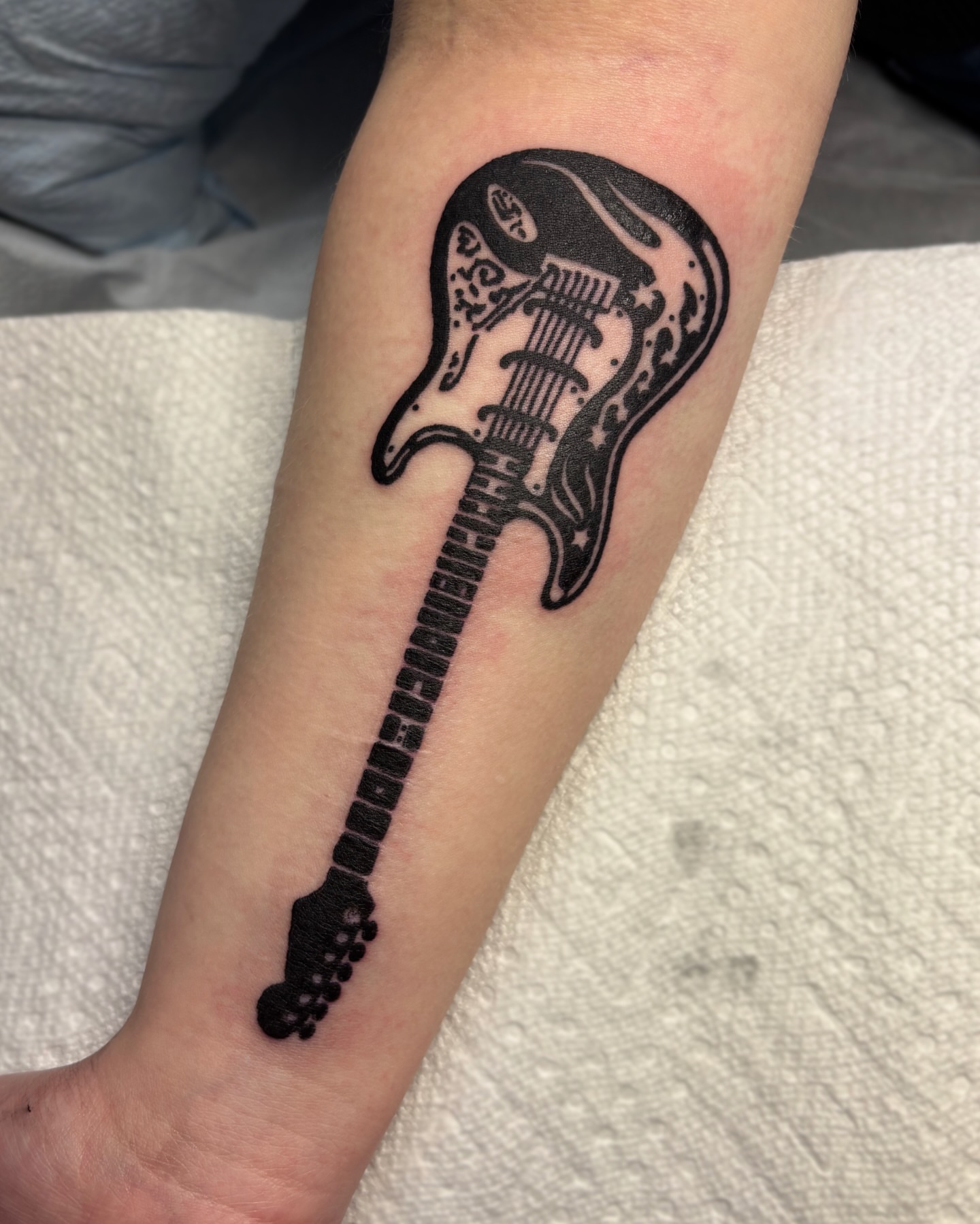 Electric guitar black and grey tattoo on the forearm by Cooper, Portland, Oregon