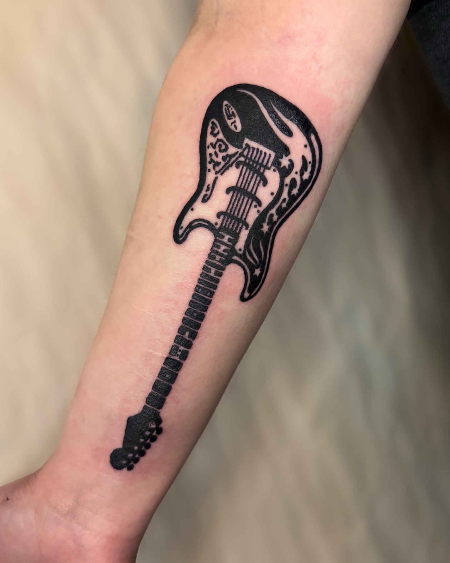 Electric guitar black and grey tattoo on the forearm by Cooper, Portland, Oregon