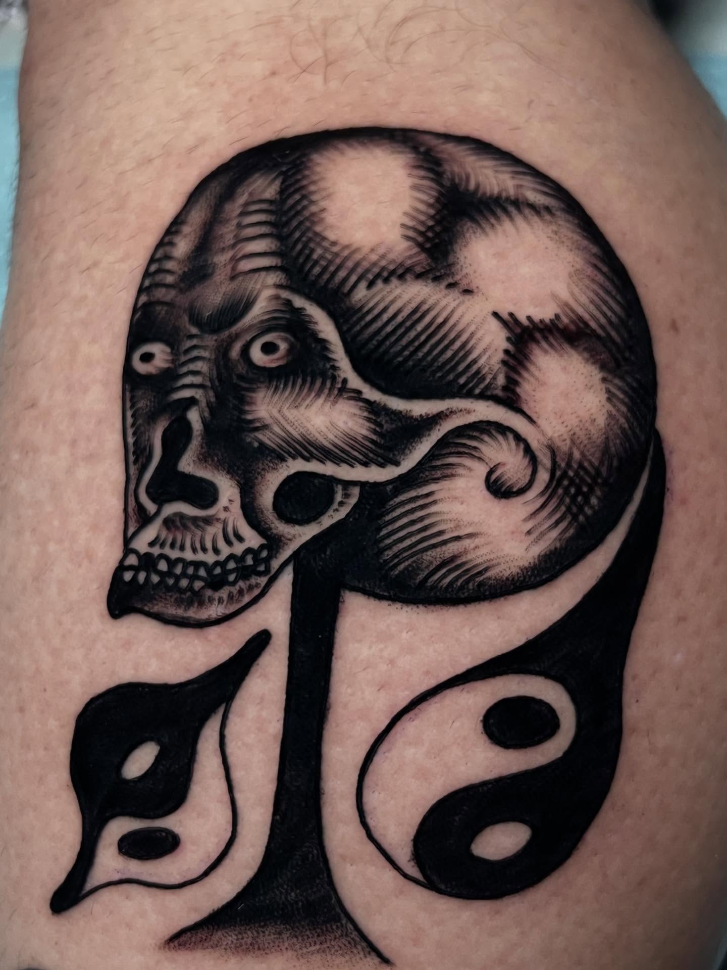 Skull and yin-yang geometric tattoo on the forearm by Charlie Campanella