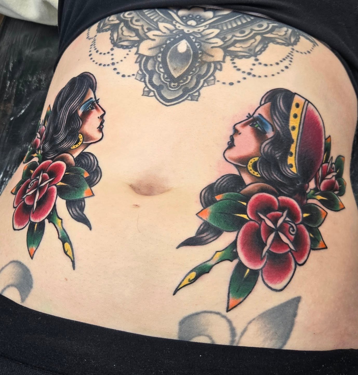 Female profile with flowers American traditional tattoo on the torso by ๐