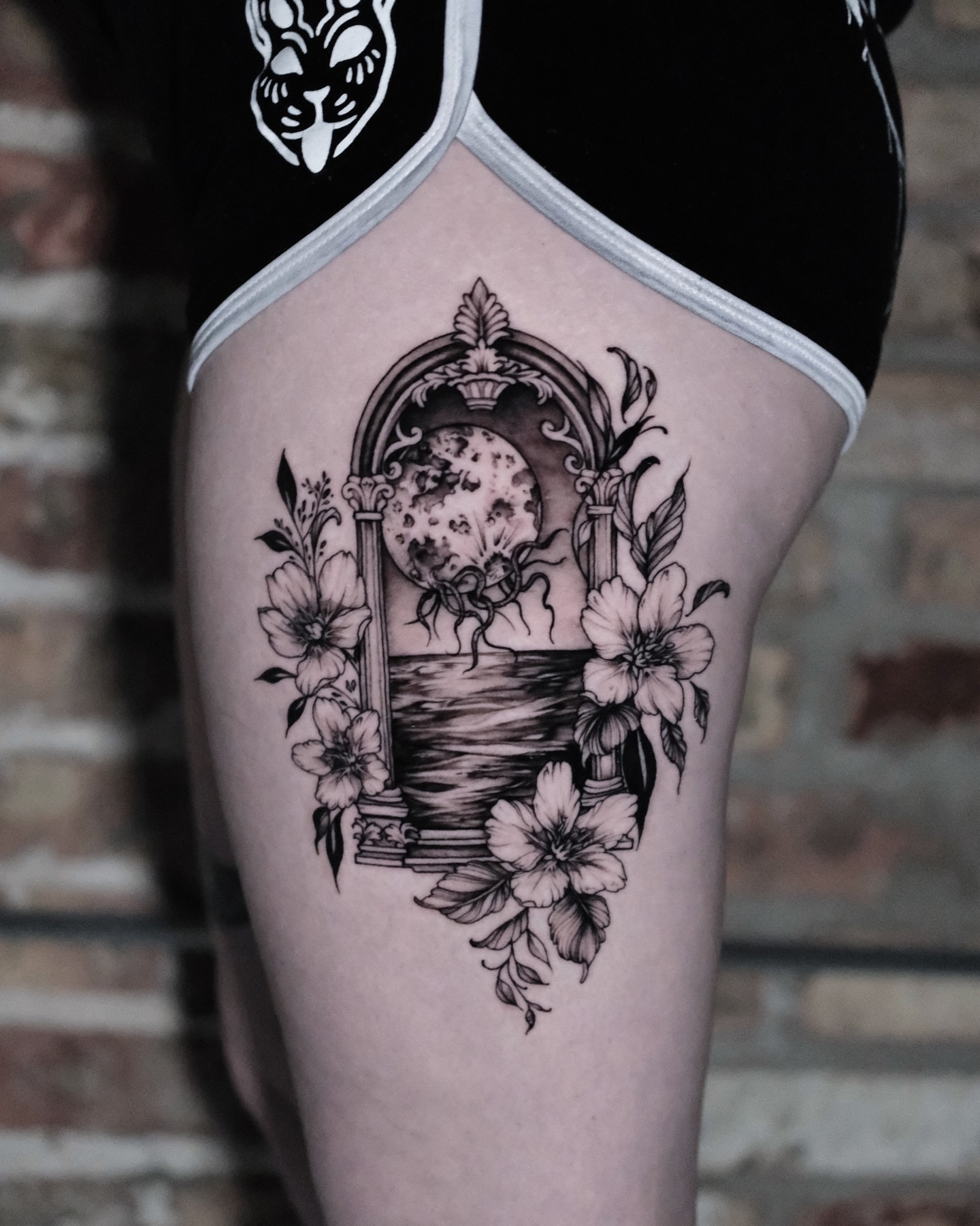 Moon and flowers ornamental tattoo on the thigh by Macayla Myers