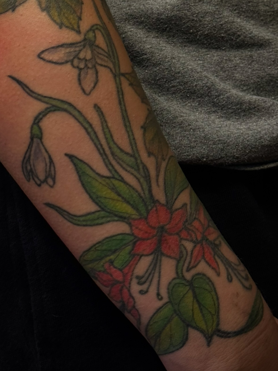 Snowdrops and fuchsia American traditional tattoo on the forearm by jess jené jones, Portland, Oregon
