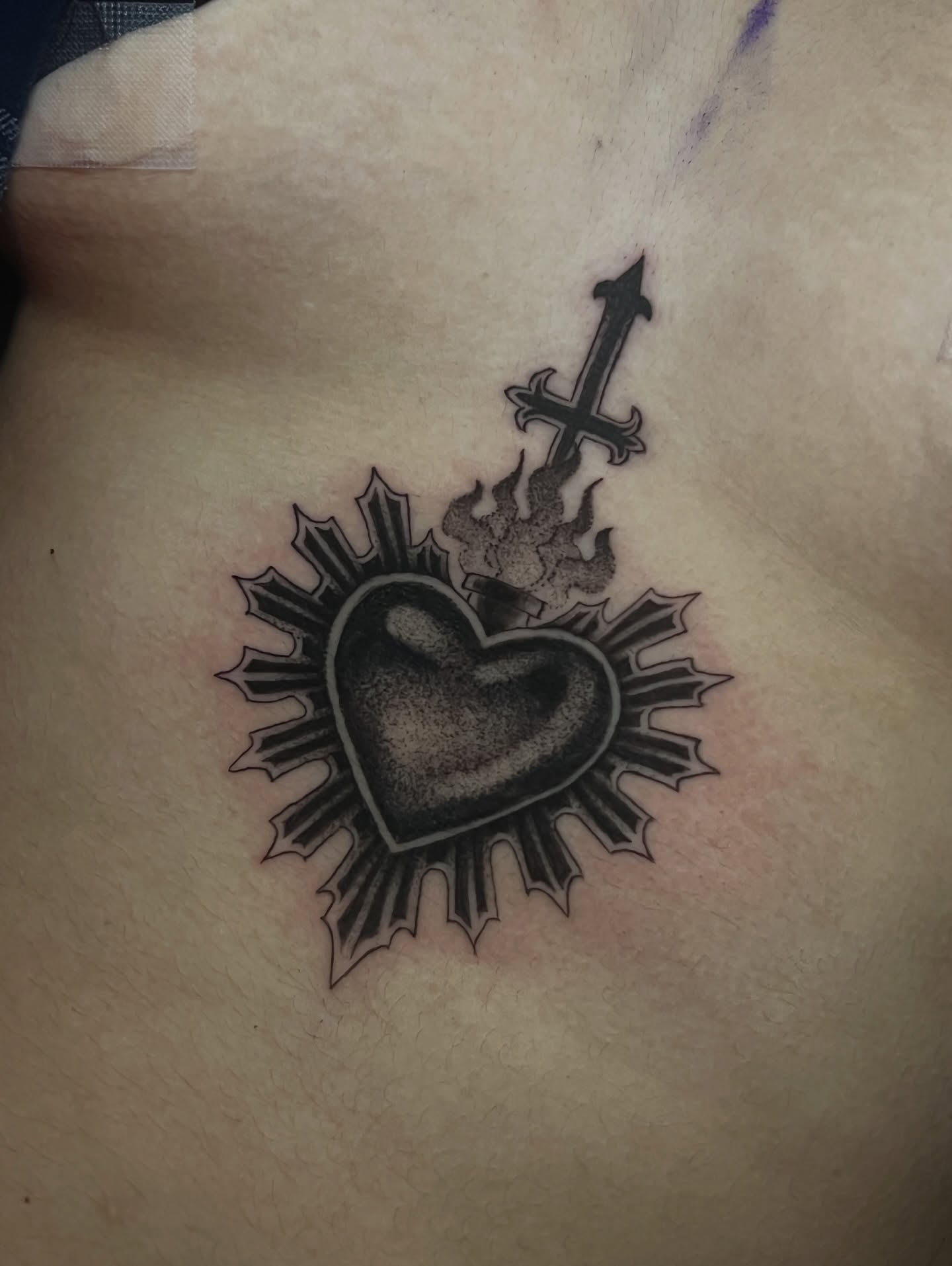 Heart with cross black and grey tattoo on the torso by πΊπππππ π»πππππππ