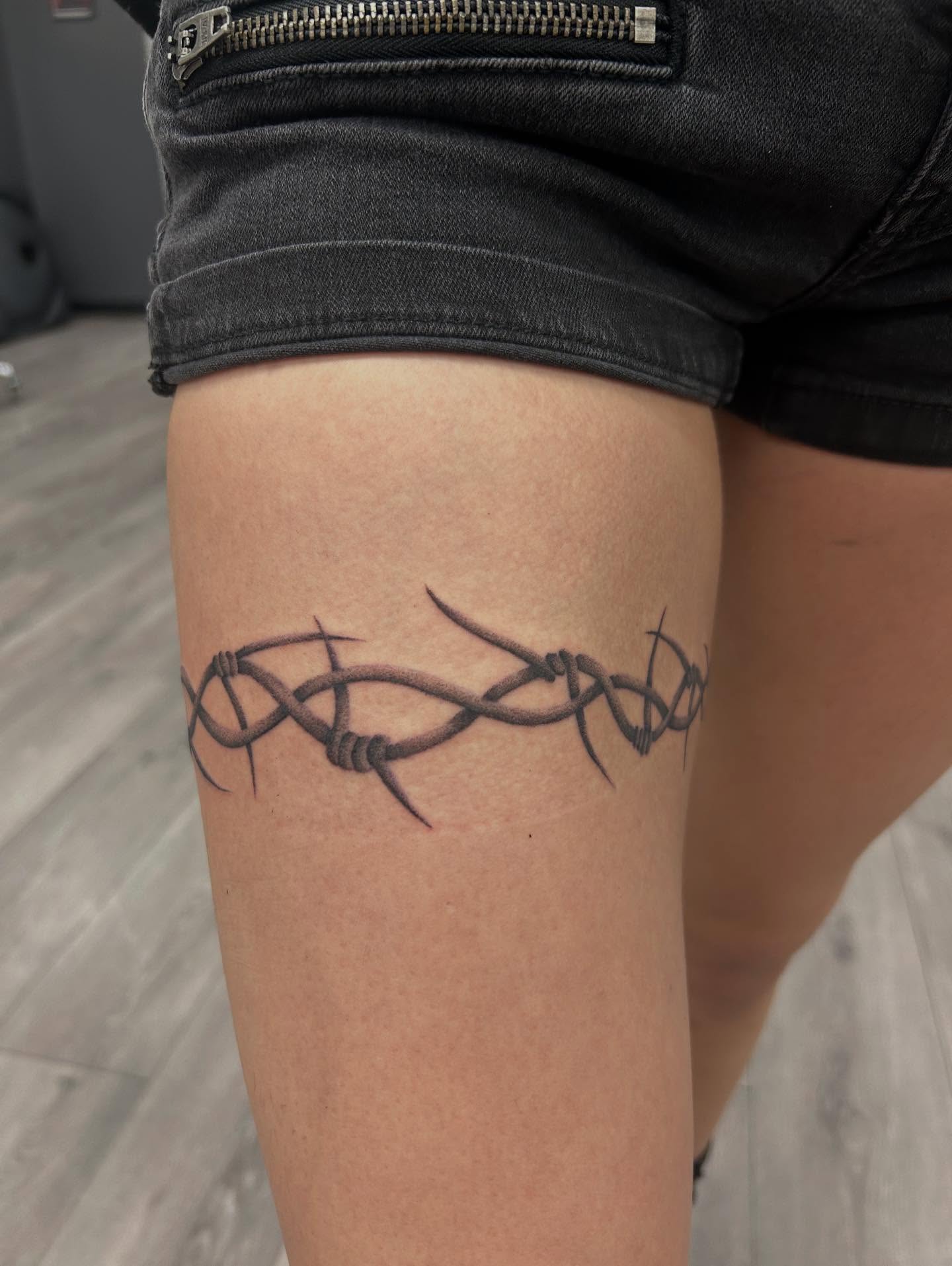 Barbed wire black and grey tattoo on the thigh by Livy baby
