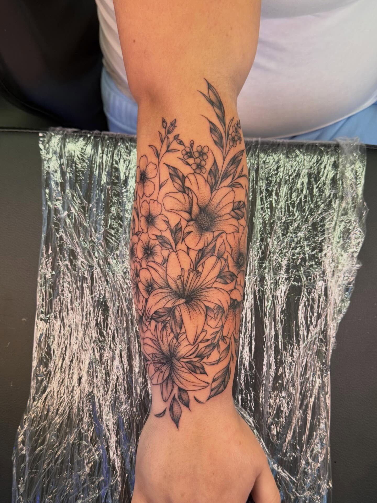 Floral bouquet black and grey tattoo on the forearm by haylie