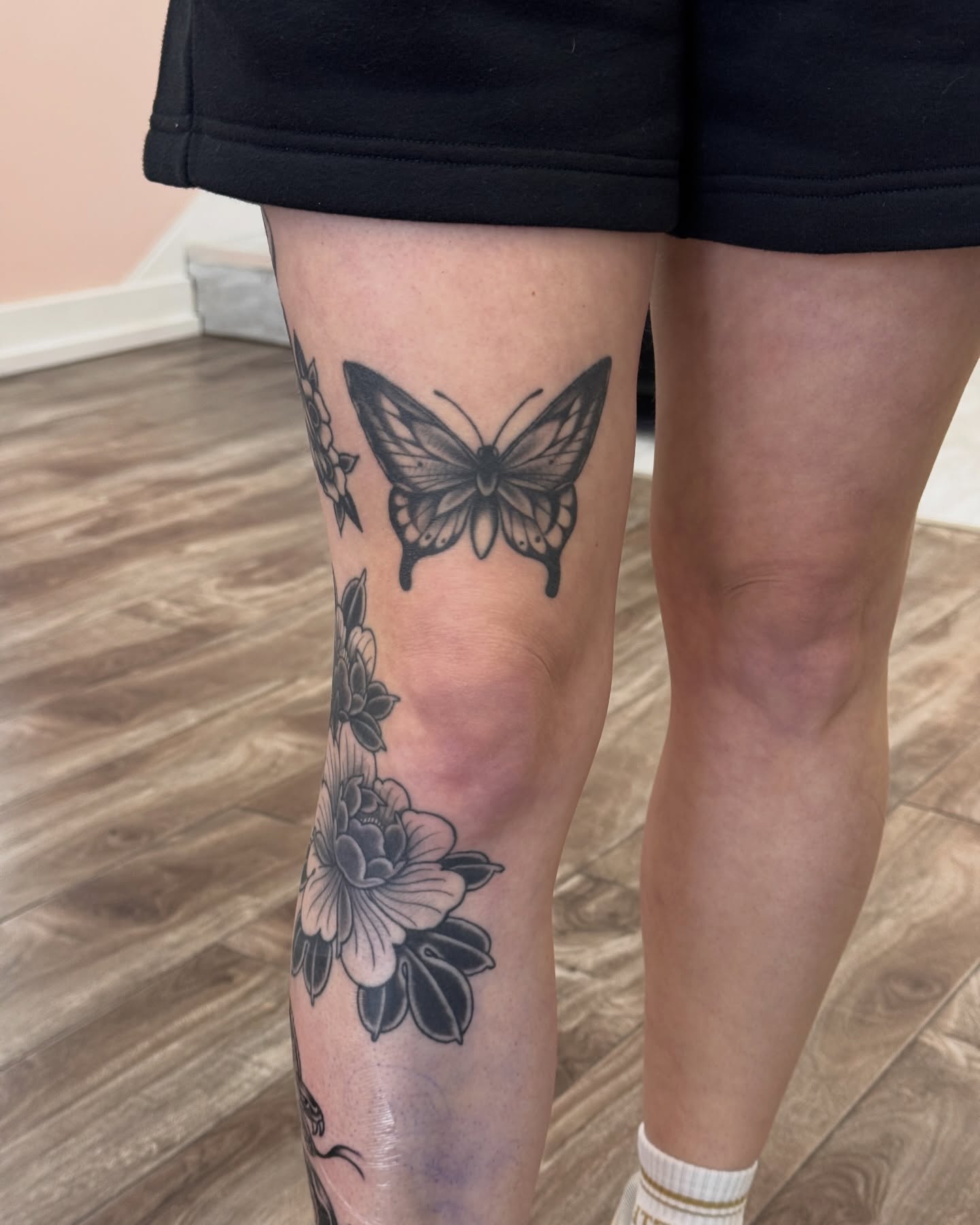 Butterfly and flowers black and grey tattoo on the leg by Bre Grover, Vancouver, British Columbia