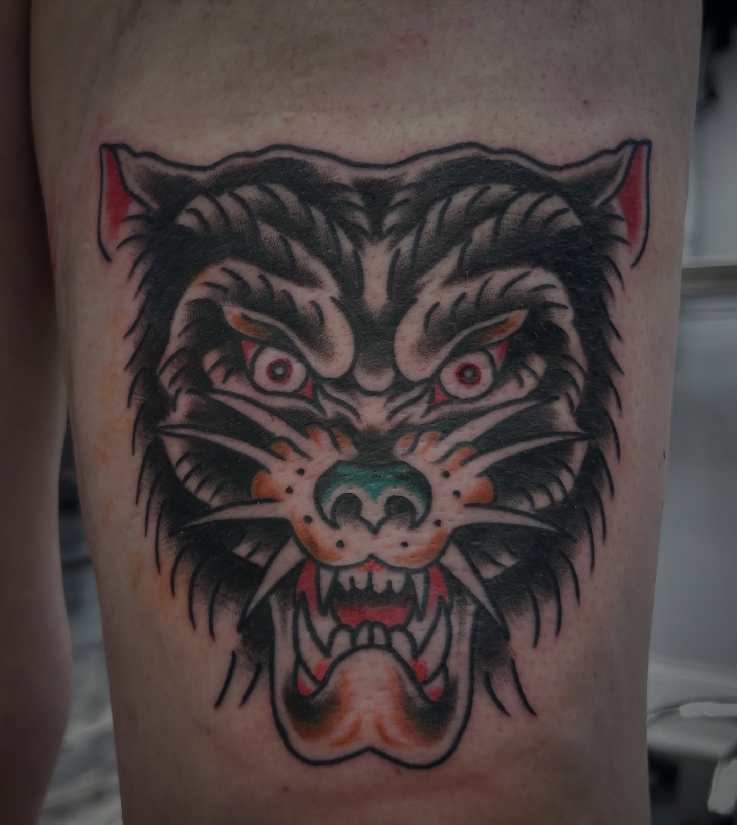 Wolf American traditional tattoo on the thigh by キノ 🦊