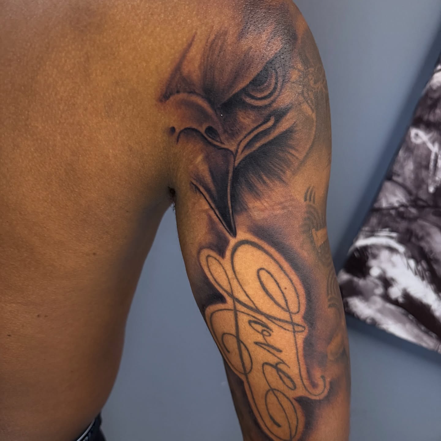 Eagle black and grey tattoo on the upper arm by Butta