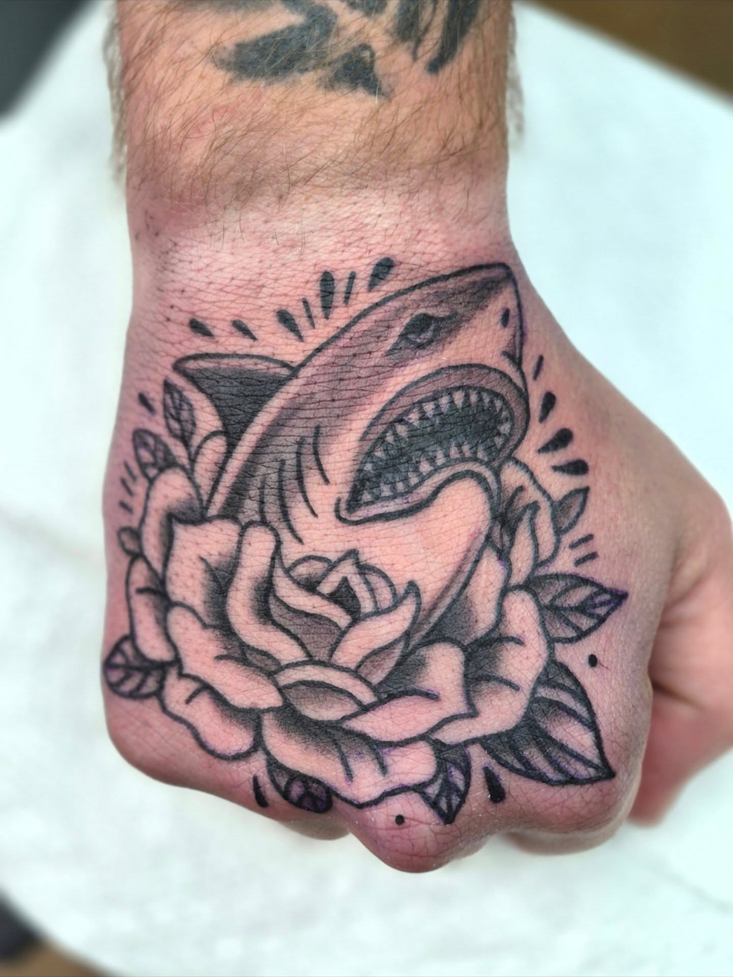 Shark in rose American traditional tattoo on the hand by Chris Bell