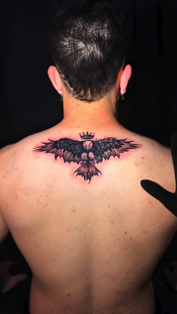Bat with crown realism tattoo on the back by Dennis Alejandro