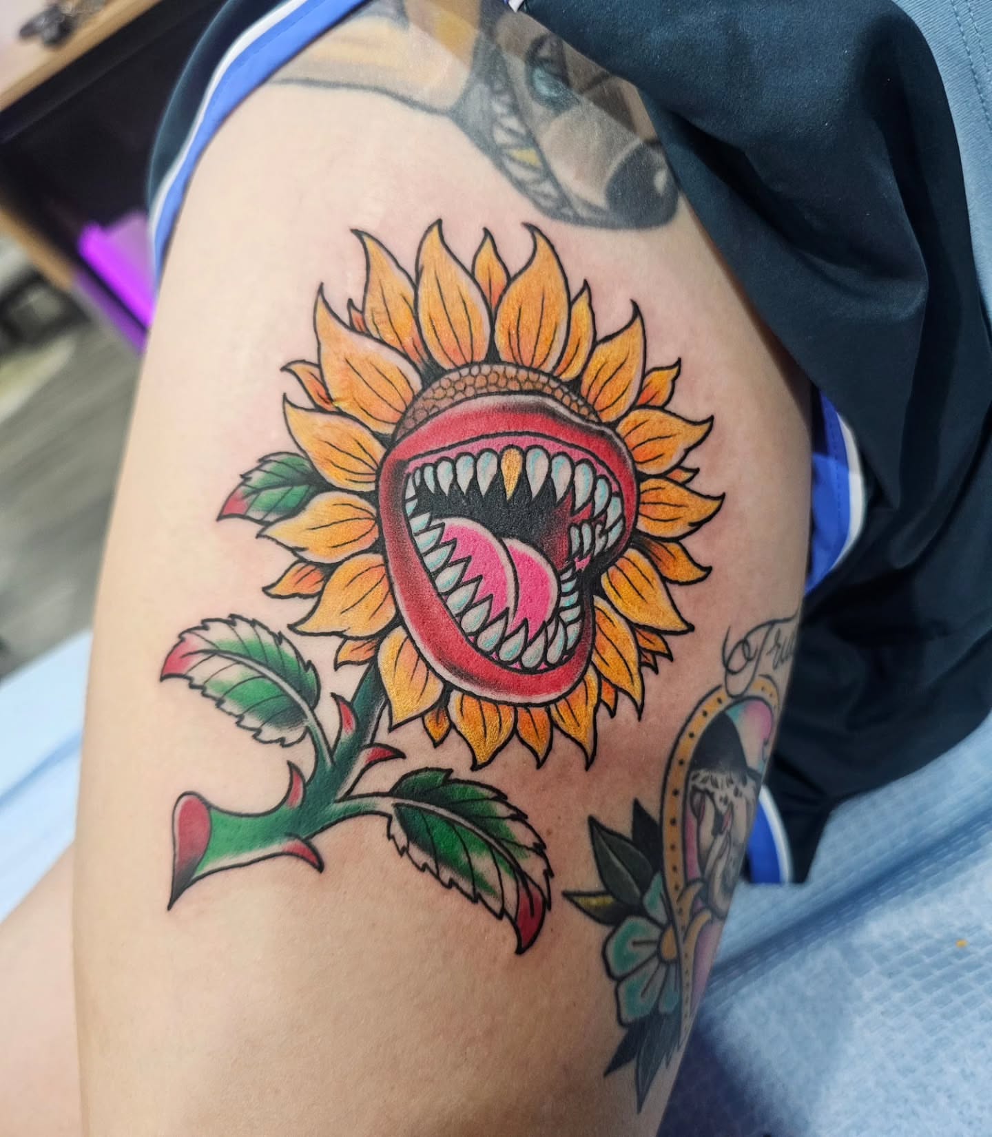Sunflower with open mouth American traditional tattoo on the thigh by Matthew Ashmore