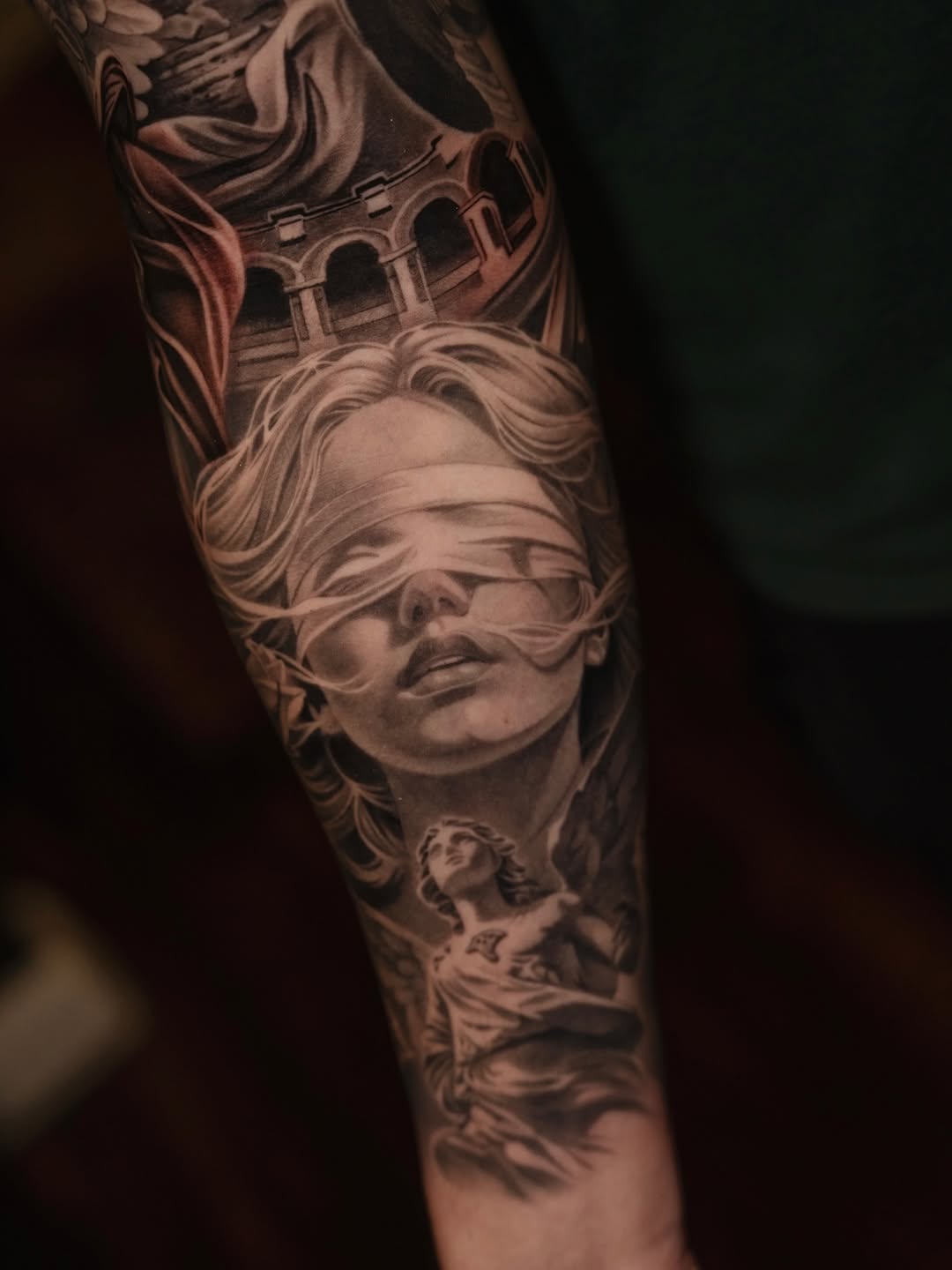 Blindfolded woman and angel realism tattoo on the forearm by @kotytattoos