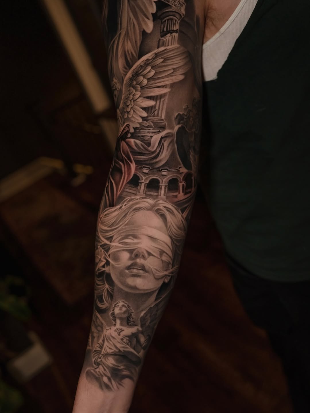 Blindfolded woman and angel realism tattoo on the forearm by @kotytattoos