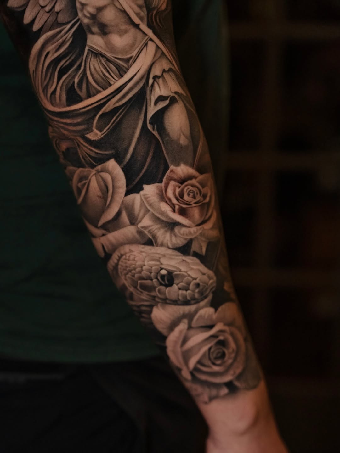 Angel and snake with roses realism tattoo on the forearm by @kotytattoos