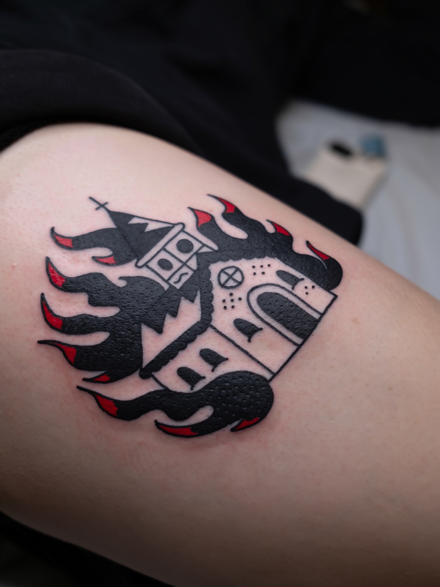 Castle in flames black and grey tattoo on the thigh by Neto Velasco - Sad Cat Tattoo, Austin, Texas