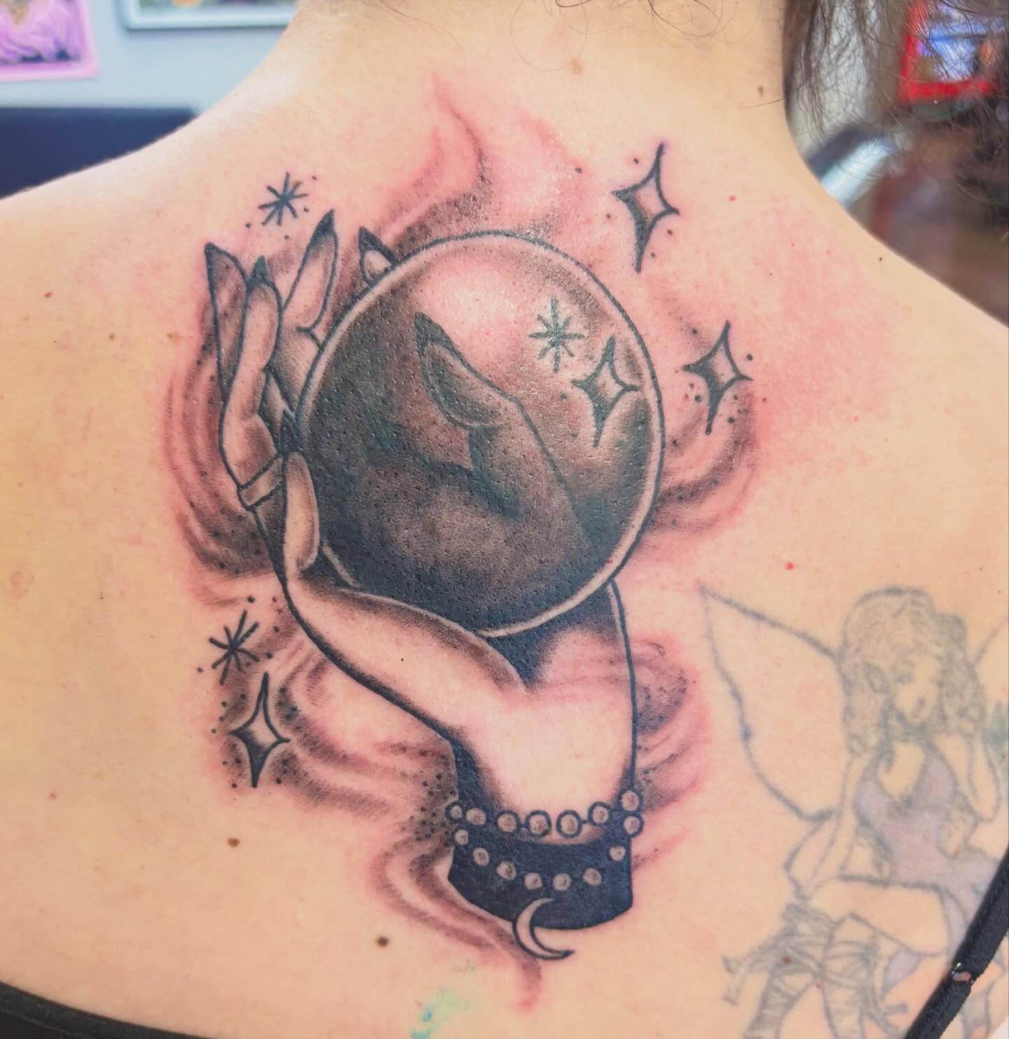 Hands holding crystal ball realism tattoo on the back by Gabby, Kansas City, Missouri