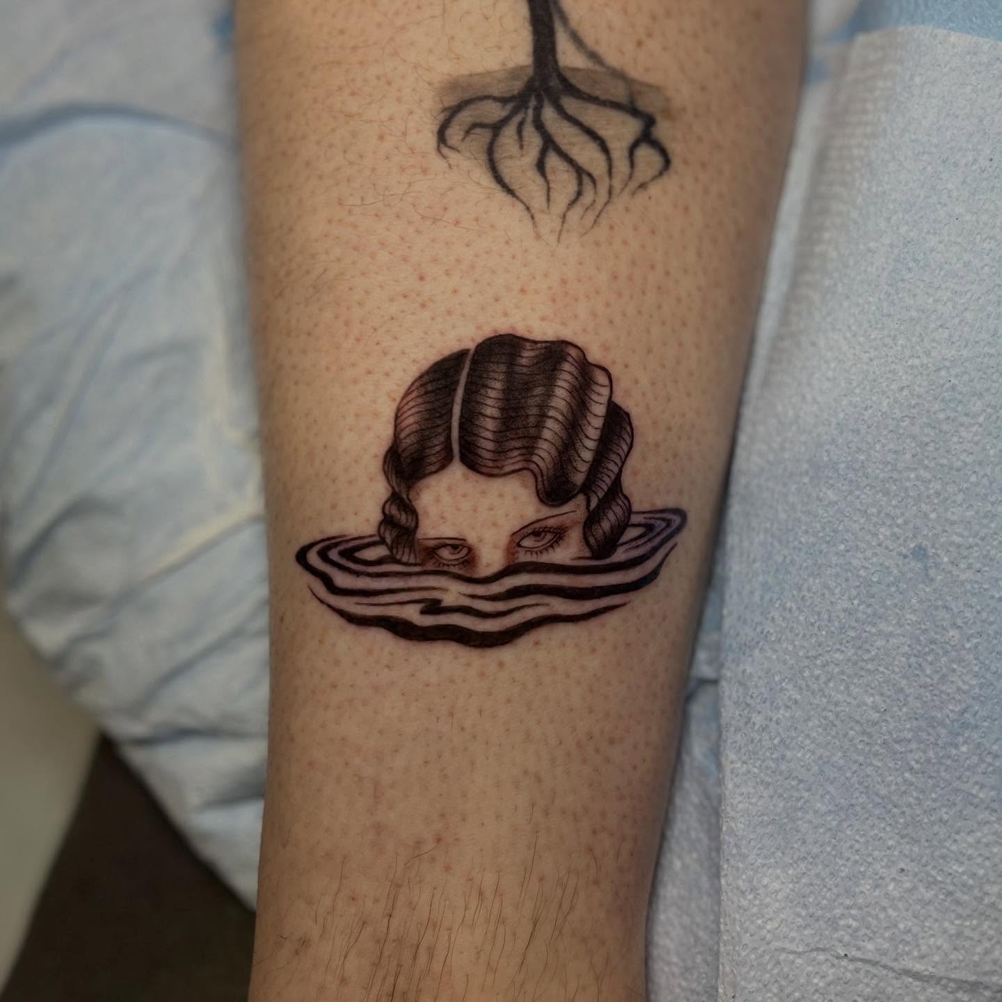 Woman's head in water realism tattoo on the forearm by Maddy Anthony