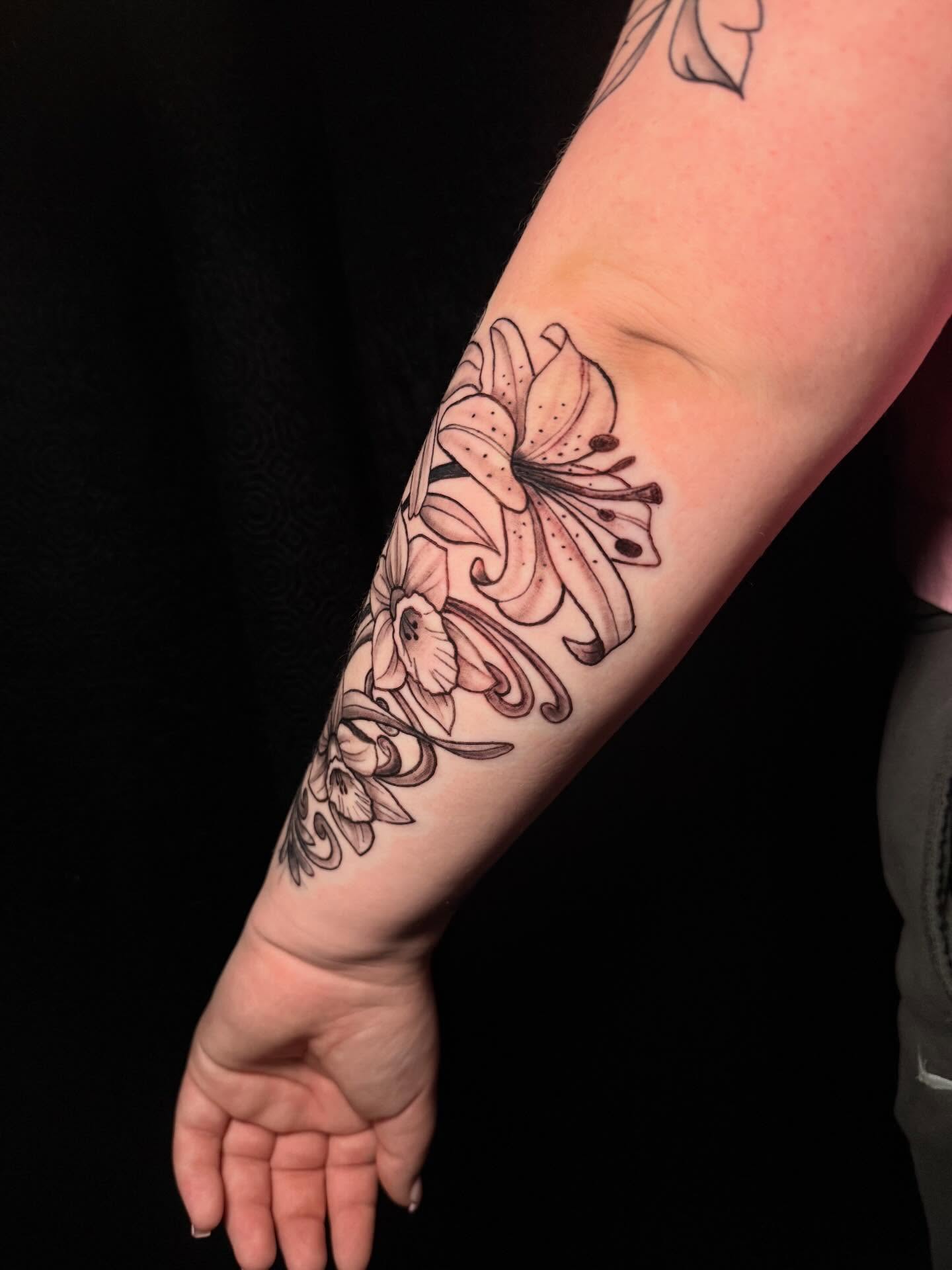 Lily black and grey tattoo on the forearm by Nicholas A. Estes-Davis