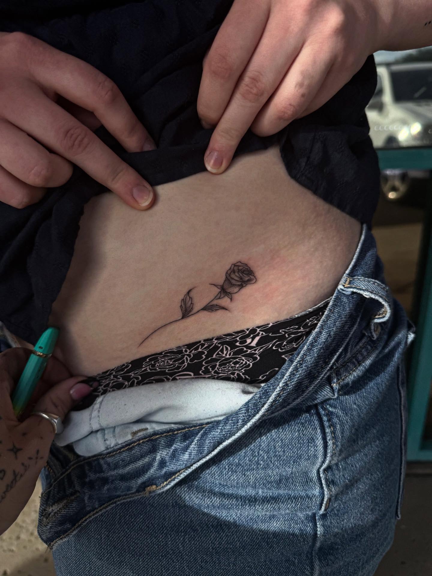 Rose black and grey tattoo on the torso by McKenna Hughes