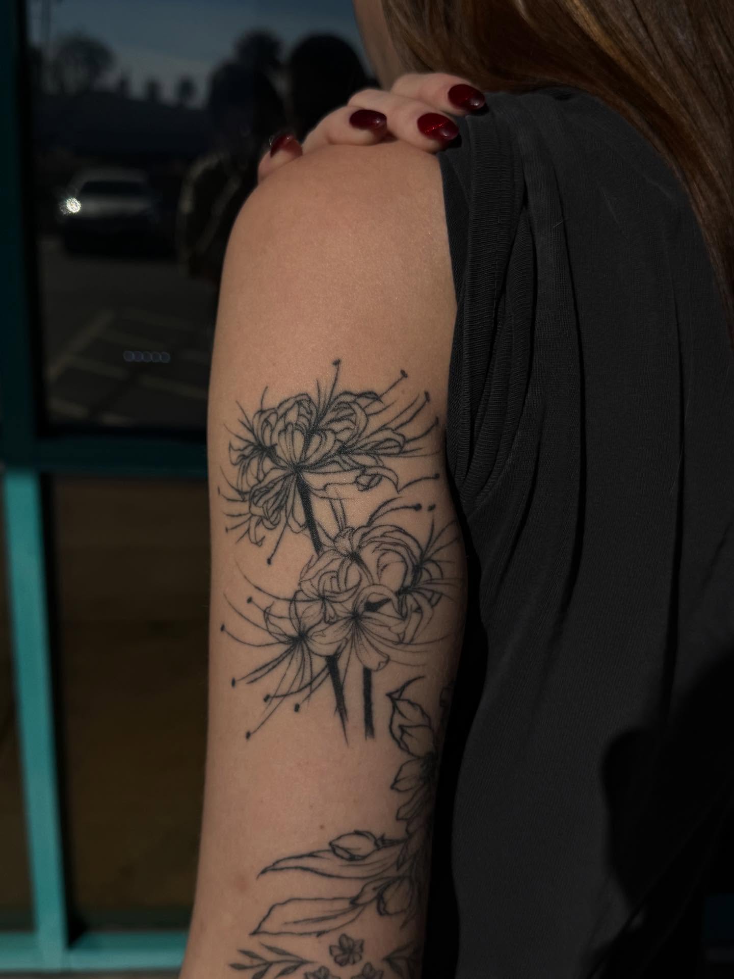 Flowers black and grey tattoo on the forearm by McKenna Hughes