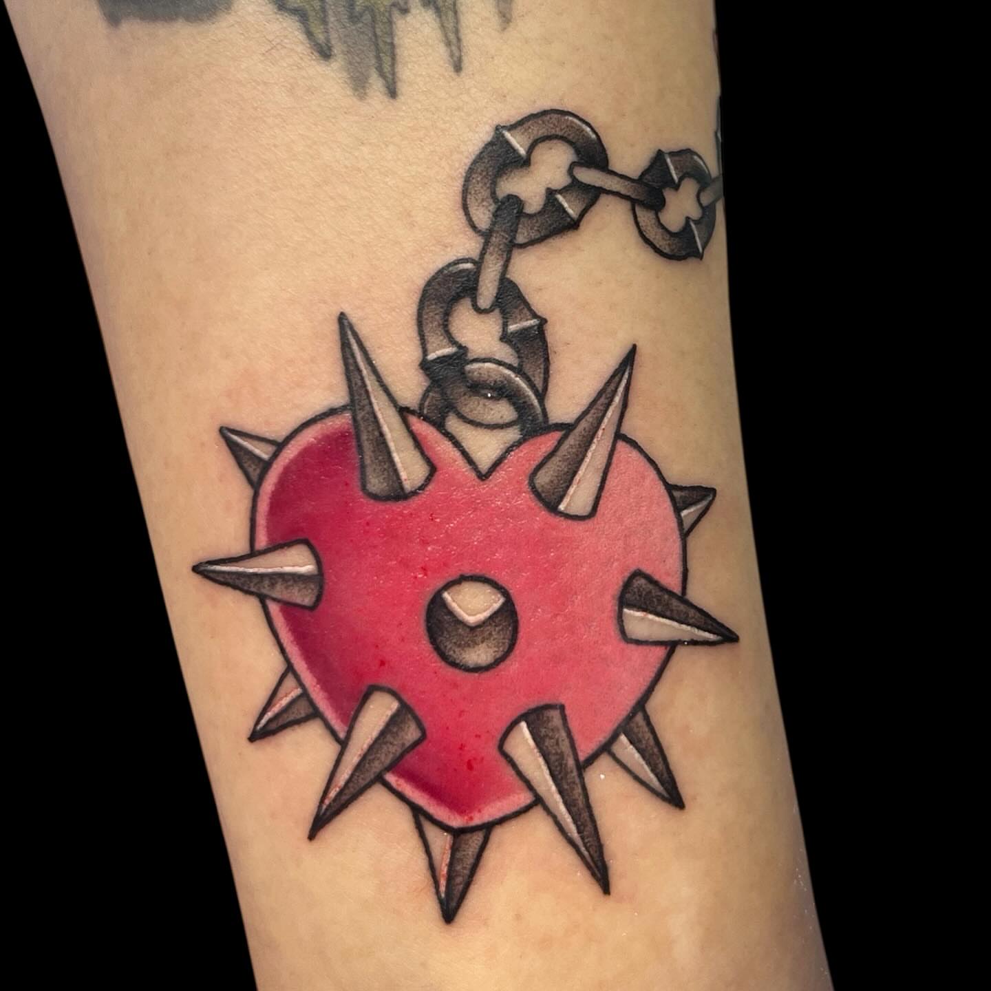 Spiked heart American traditional tattoo on the forearm by Nicole Skalski