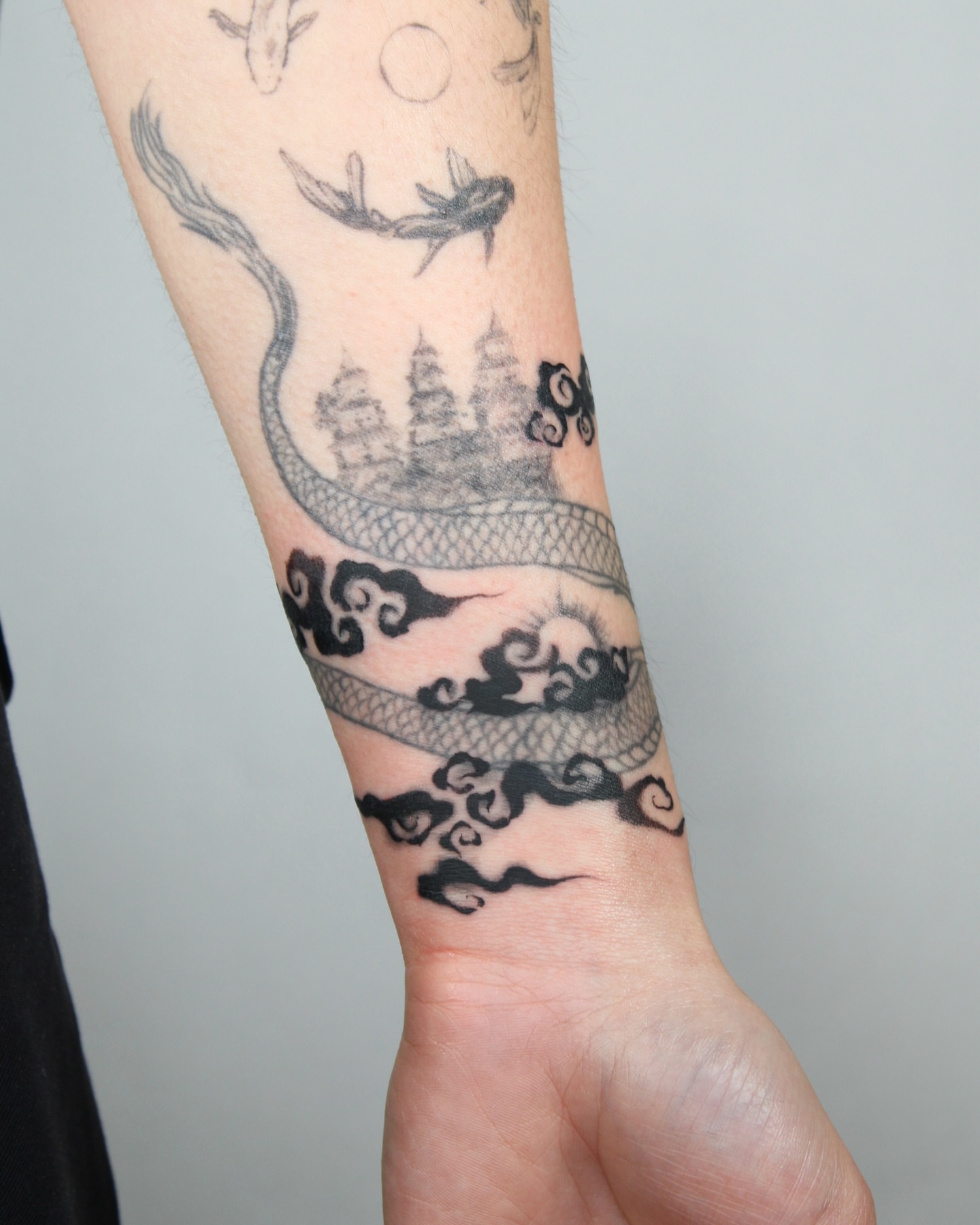 Dragon and temple black and grey tattoo on the forearm by Piao
