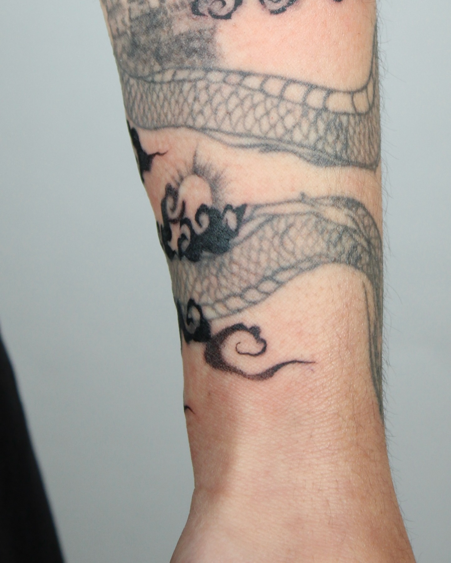 Dragon black and grey tattoo on the forearm by Piao