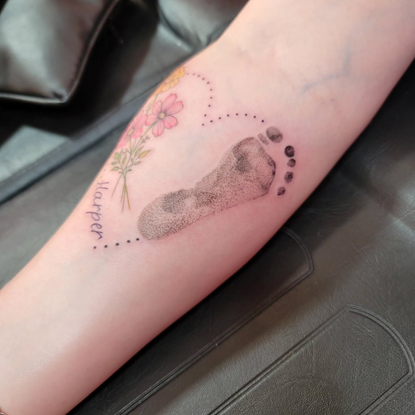 Footprint with flowers dotwork tattoo on the forearm by Mary Lefeau