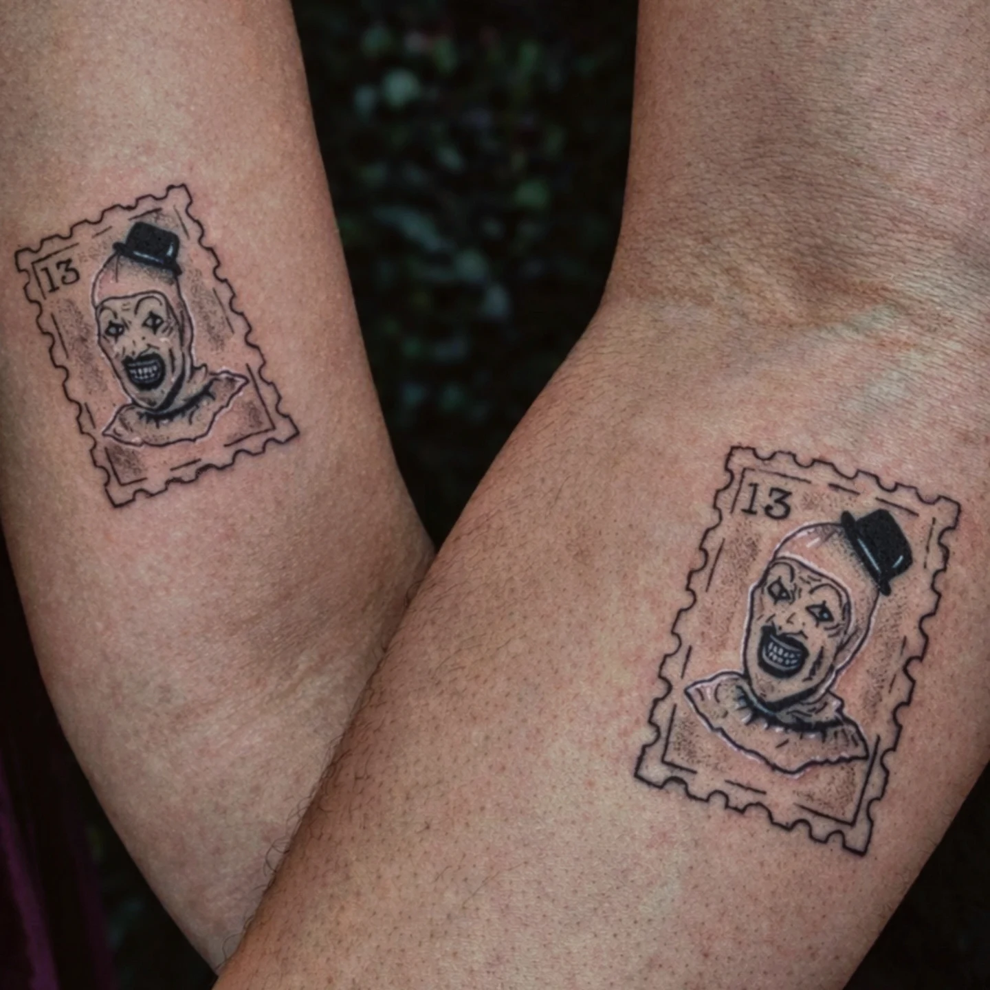 Clown postage stamp black and grey tattoo on the forearm by Marlayna Connelly