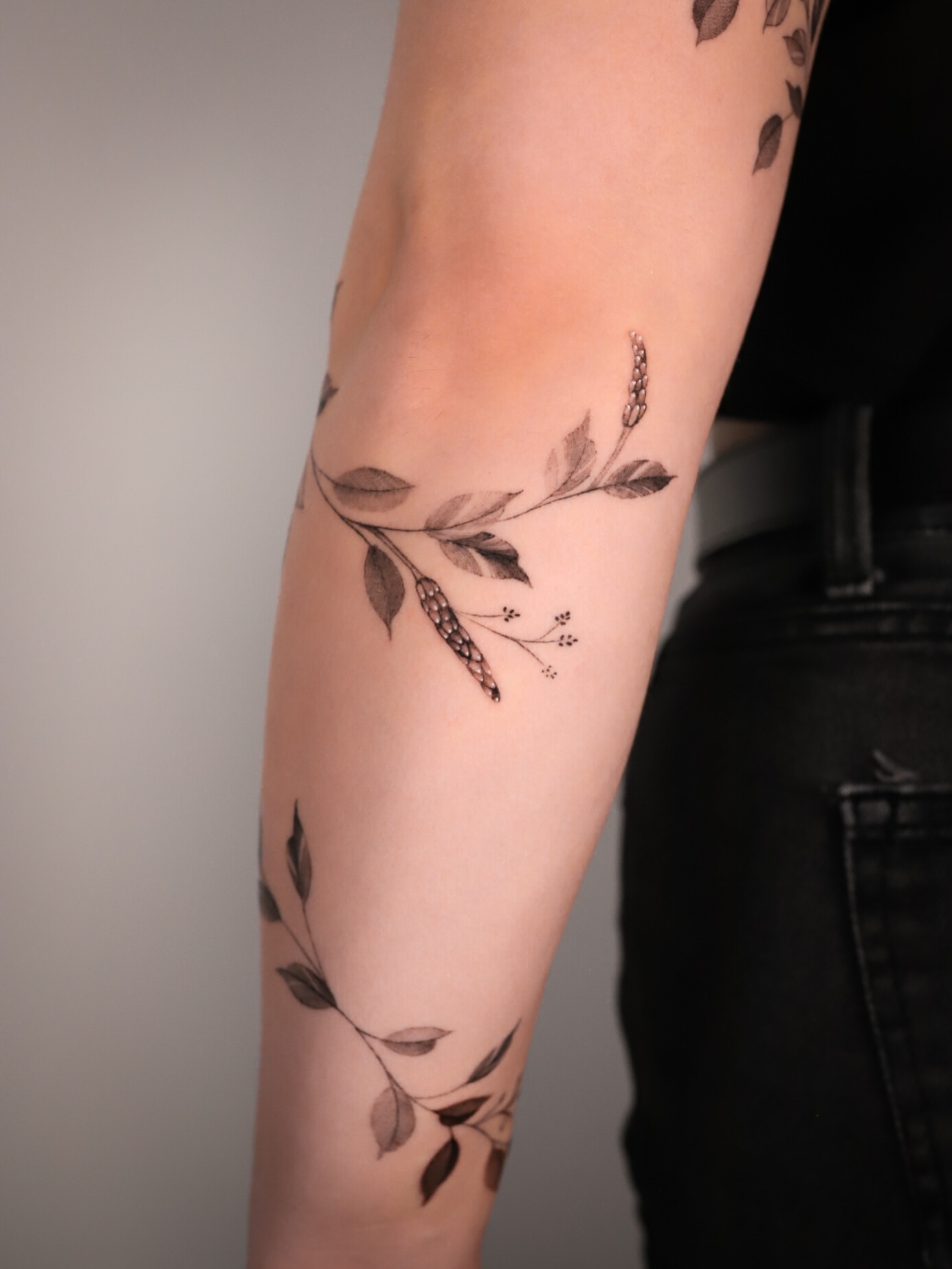 Botanical branch black and grey tattoo on the forearm by Cyn